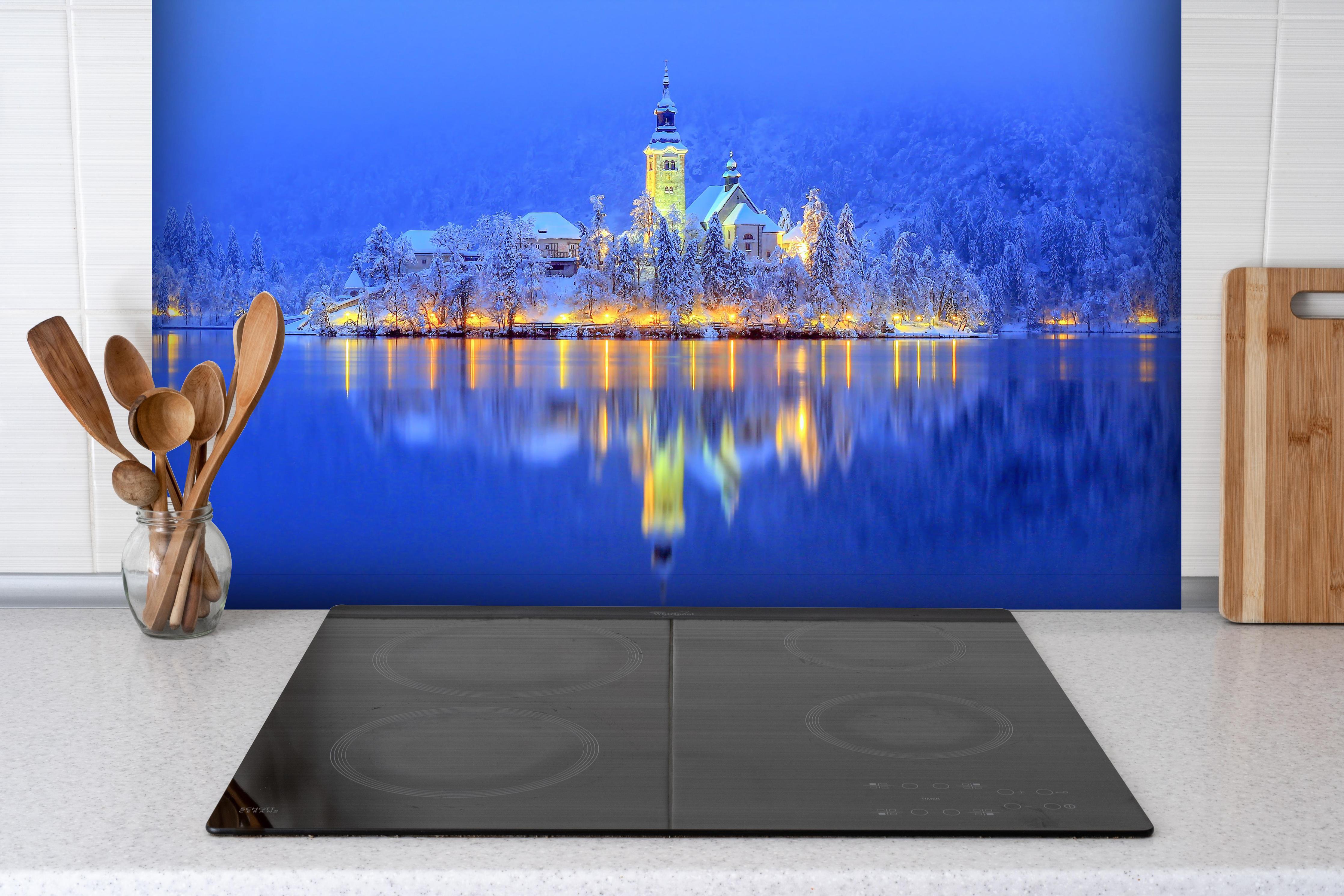 Spritzschutz - Bled Island hinter einem Cerankochfeld zwischen Holz-Kochutensilien
