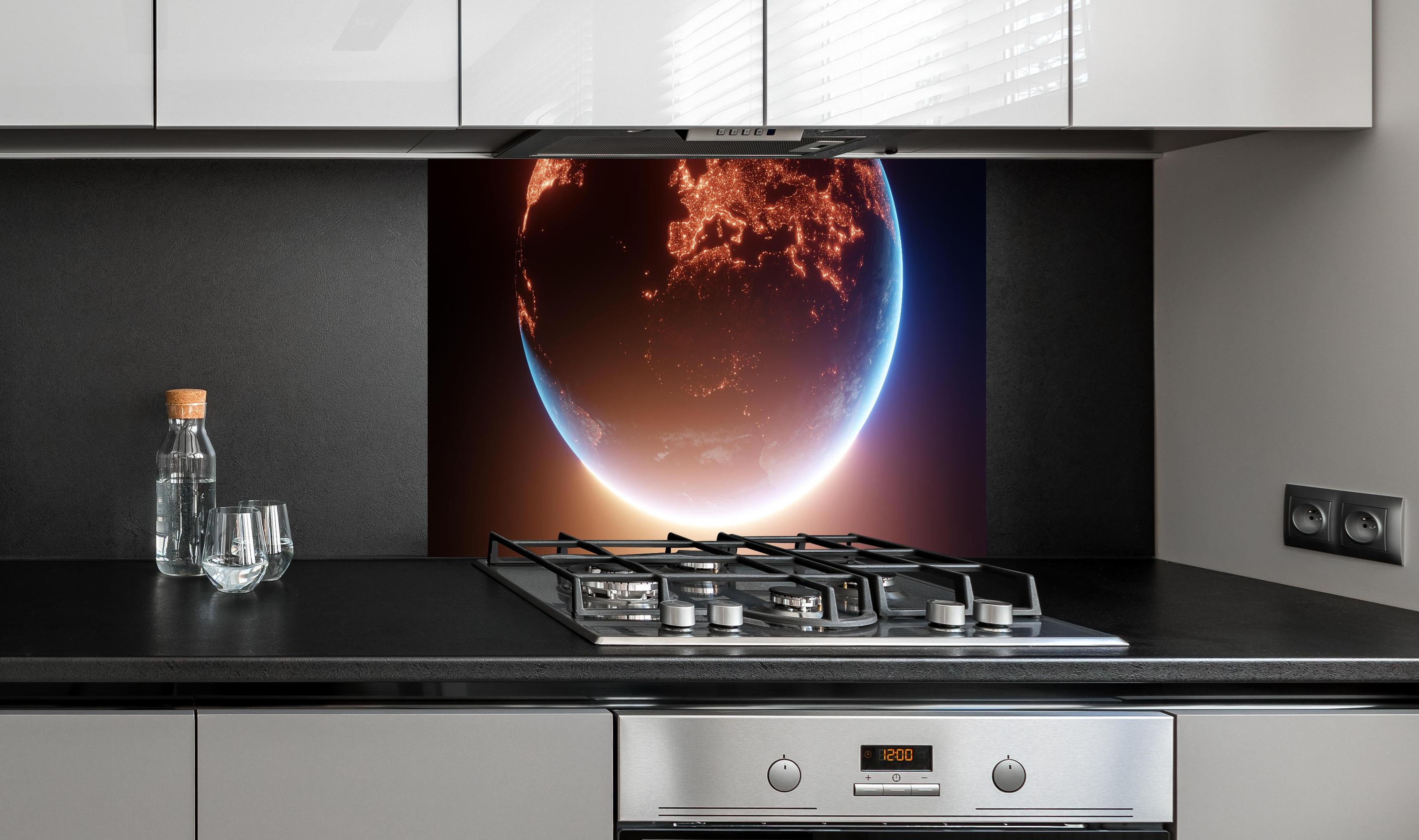 Spritzschutz - Blick auf Planeten hinter einem Cerankochfeld zwischen Holz-Kochutensilien
