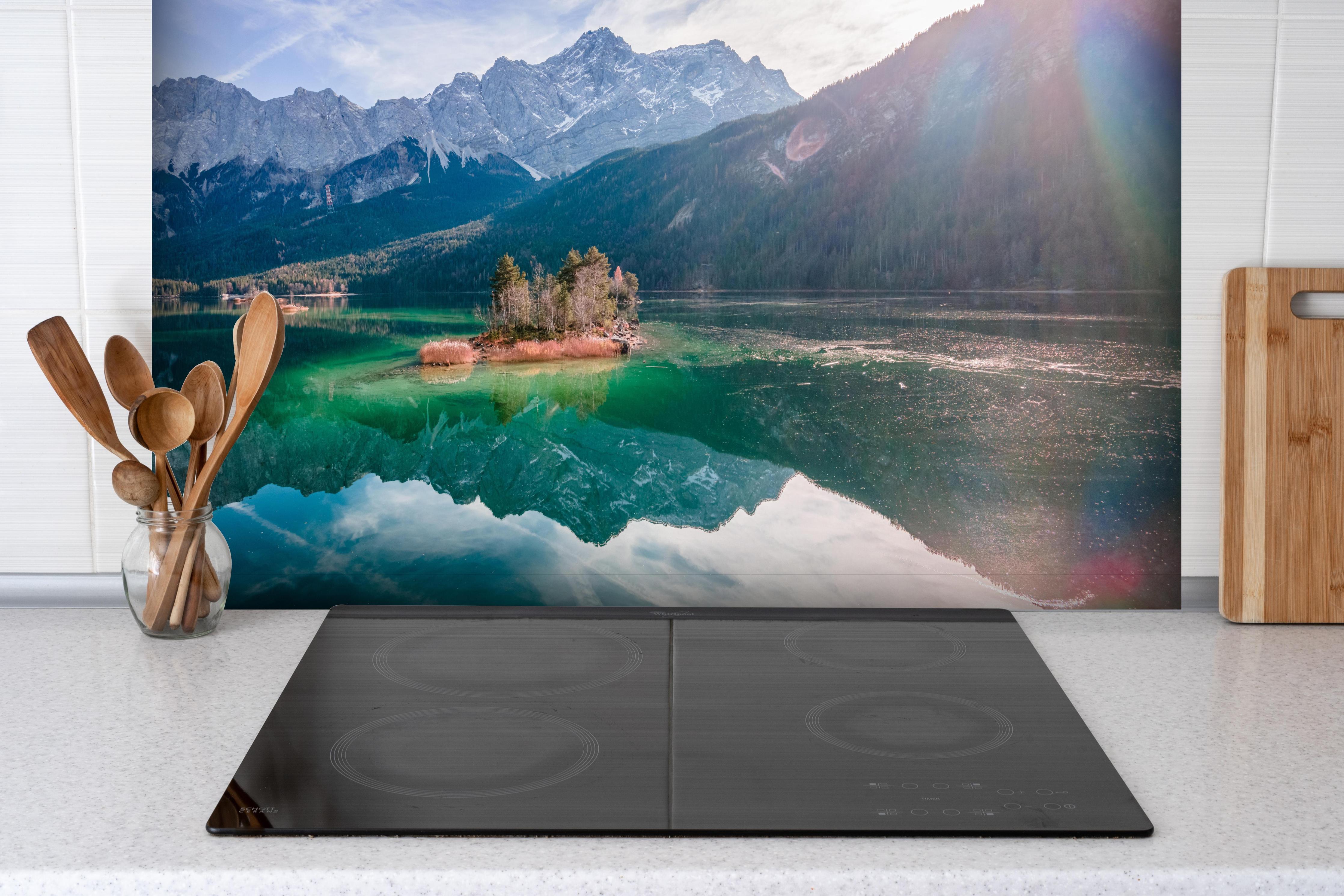 Spritzschutz - Blick auf den Eibsee mit der Zugspitze im Hintergrund hinter einem Cerankochfeld zwischen Holz-Kochutensilien
