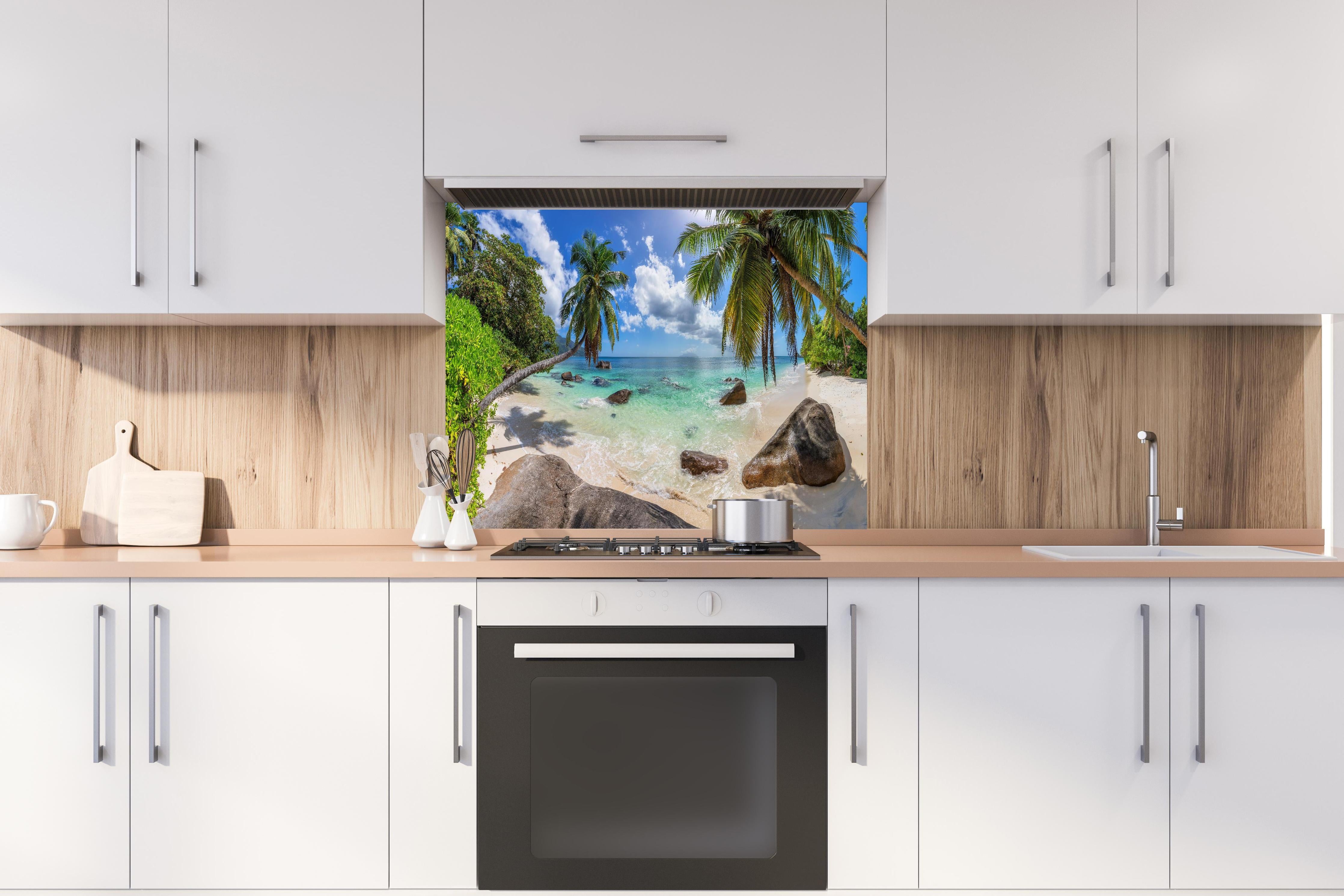 Spritzschutz - Blick auf den schönen tropischen Strand hinter einem Cerankochfeld zwischen Holz-Kochutensilien
