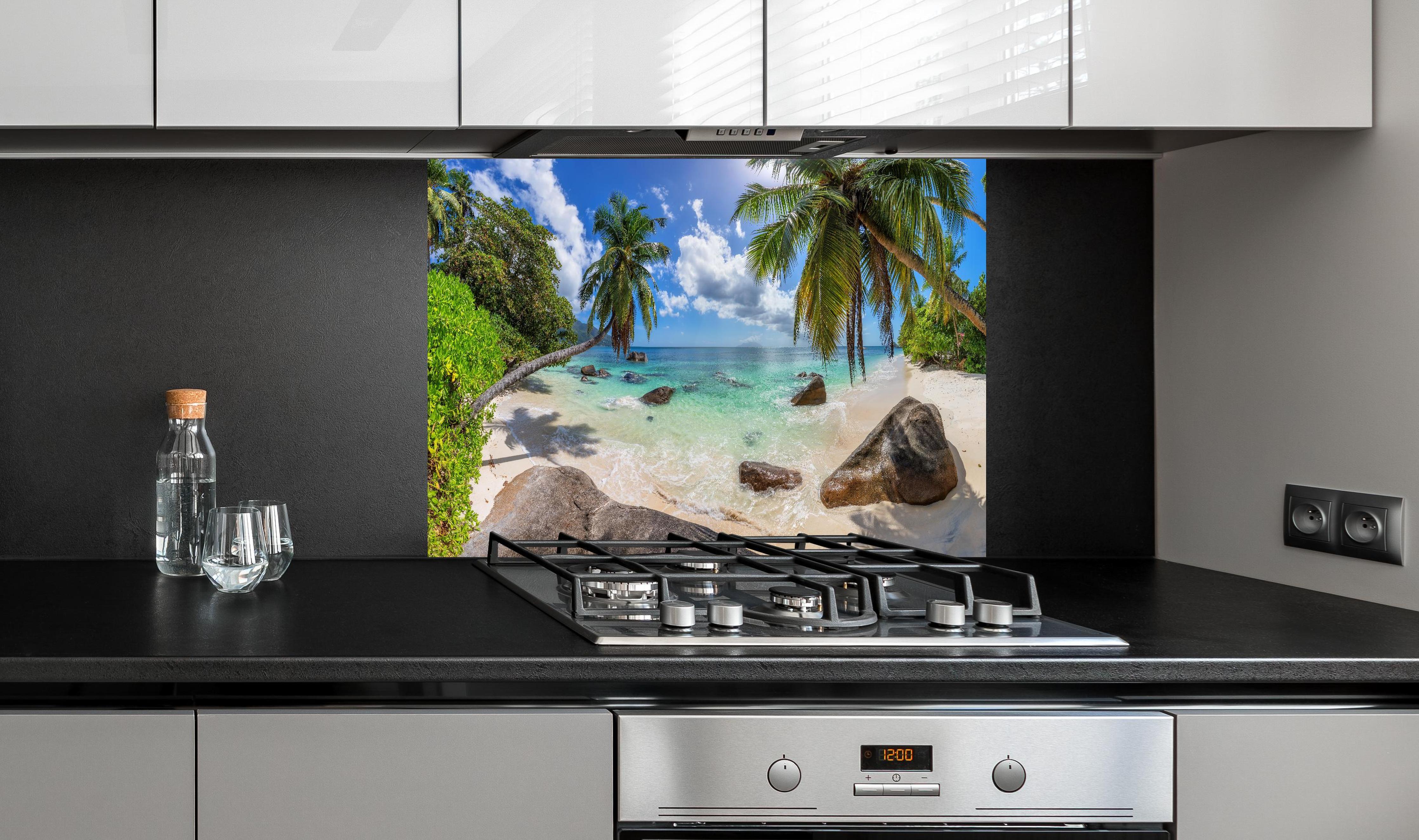 Spritzschutz - Blick auf den schönen tropischen Strand hinter einem Cerankochfeld zwischen Holz-Kochutensilien
