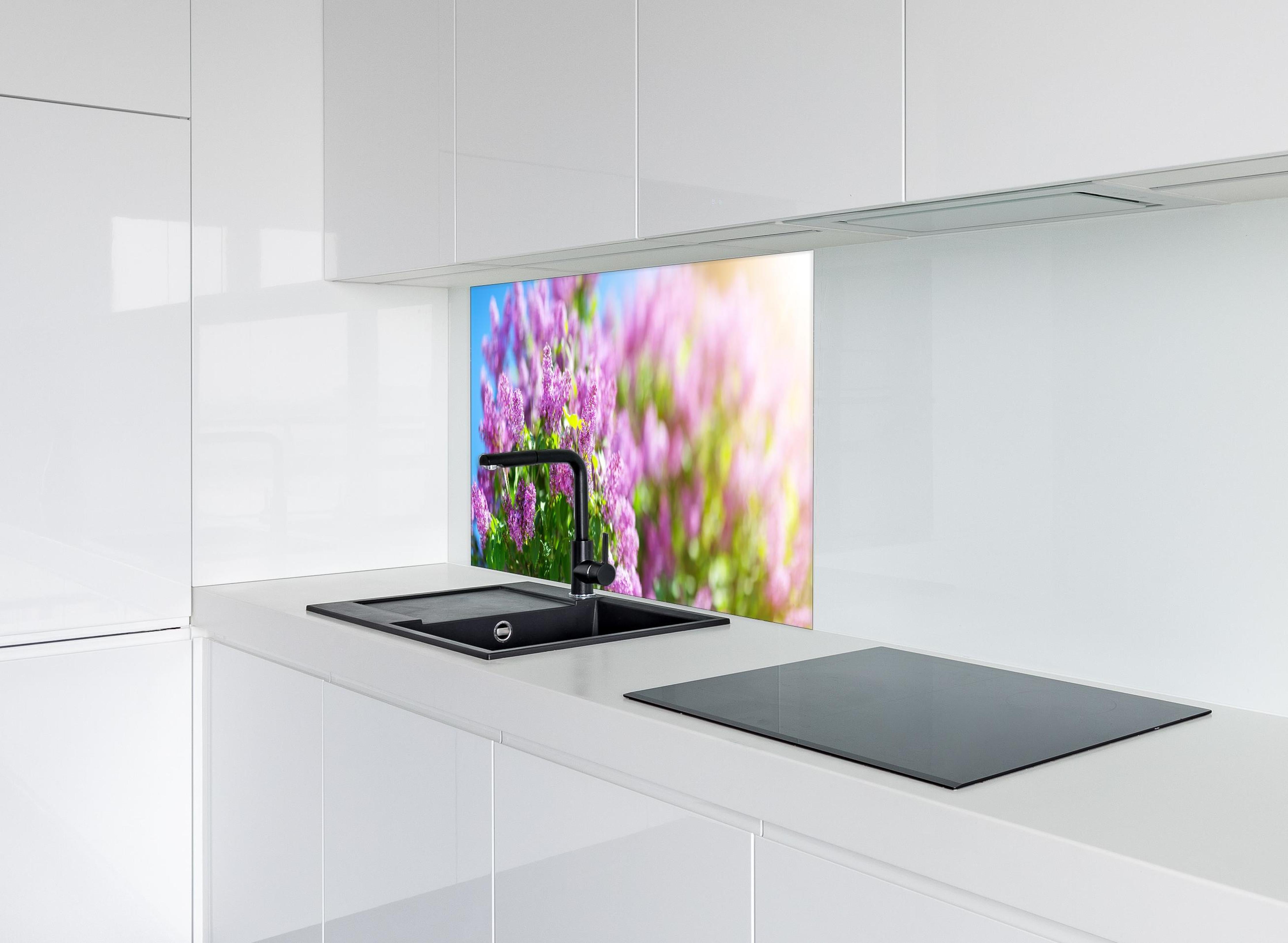 Spritzschutz - Blumen blühen auf im Frühling hinter einem Cerankochfeld zwischen Holz-Kochutensilien
