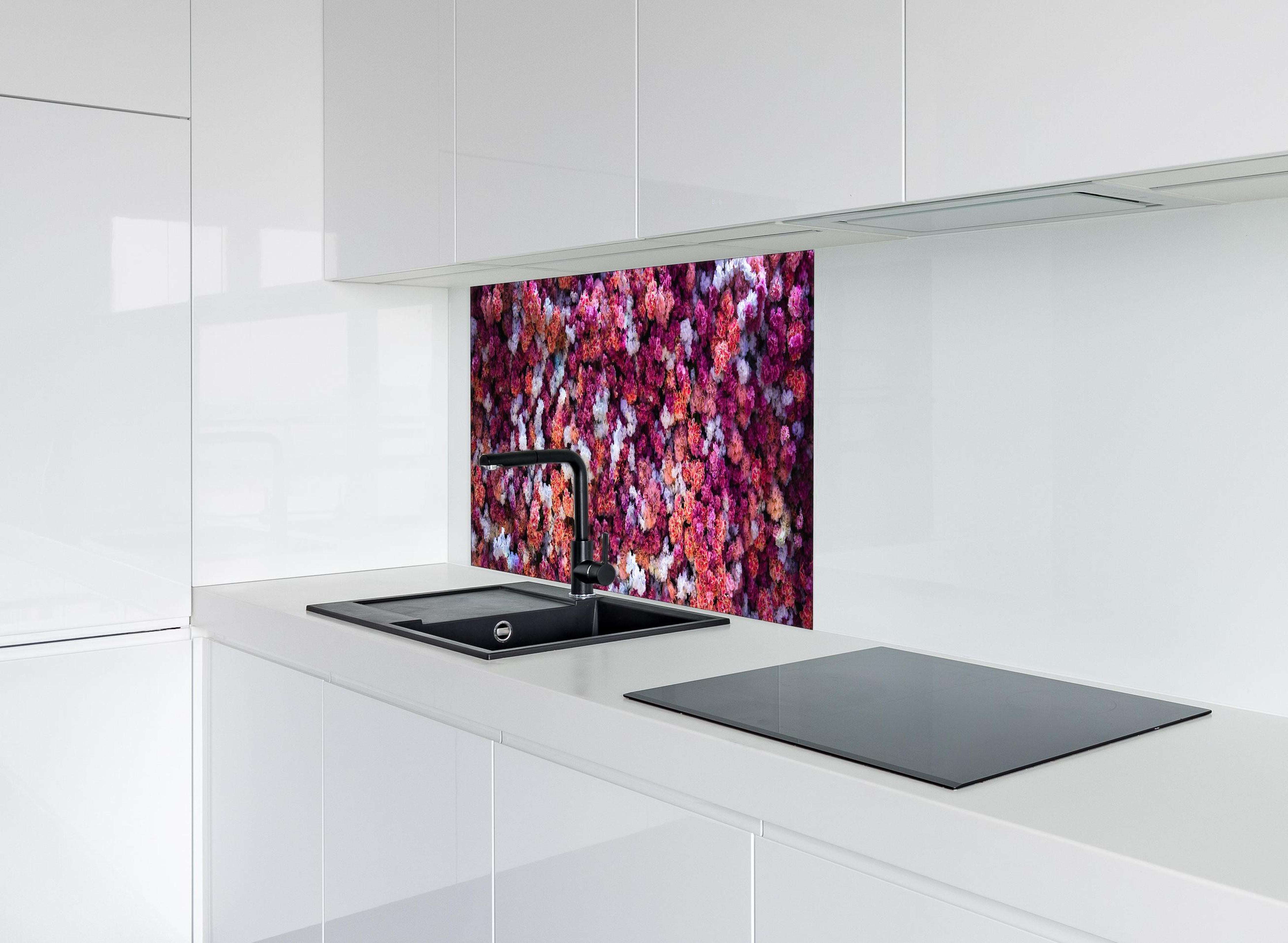 Spritzschutz - Blumenwand in Rot und Weiß Naturhintergrund hinter einem Cerankochfeld zwischen Holz-Kochutensilien
