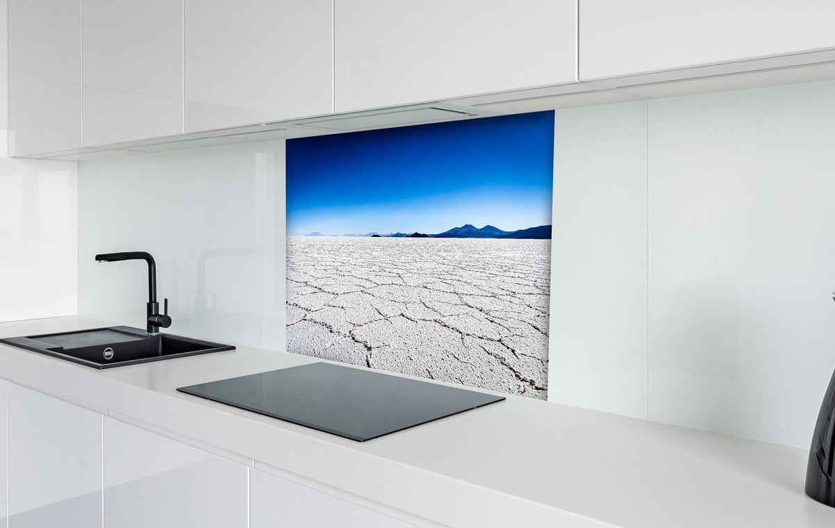 Spritzschutz - Bolivien Salar Uyuni Weiß-Blau Himmel hinter einem Cerankochfeld zwischen Holz-Kochutensilien
