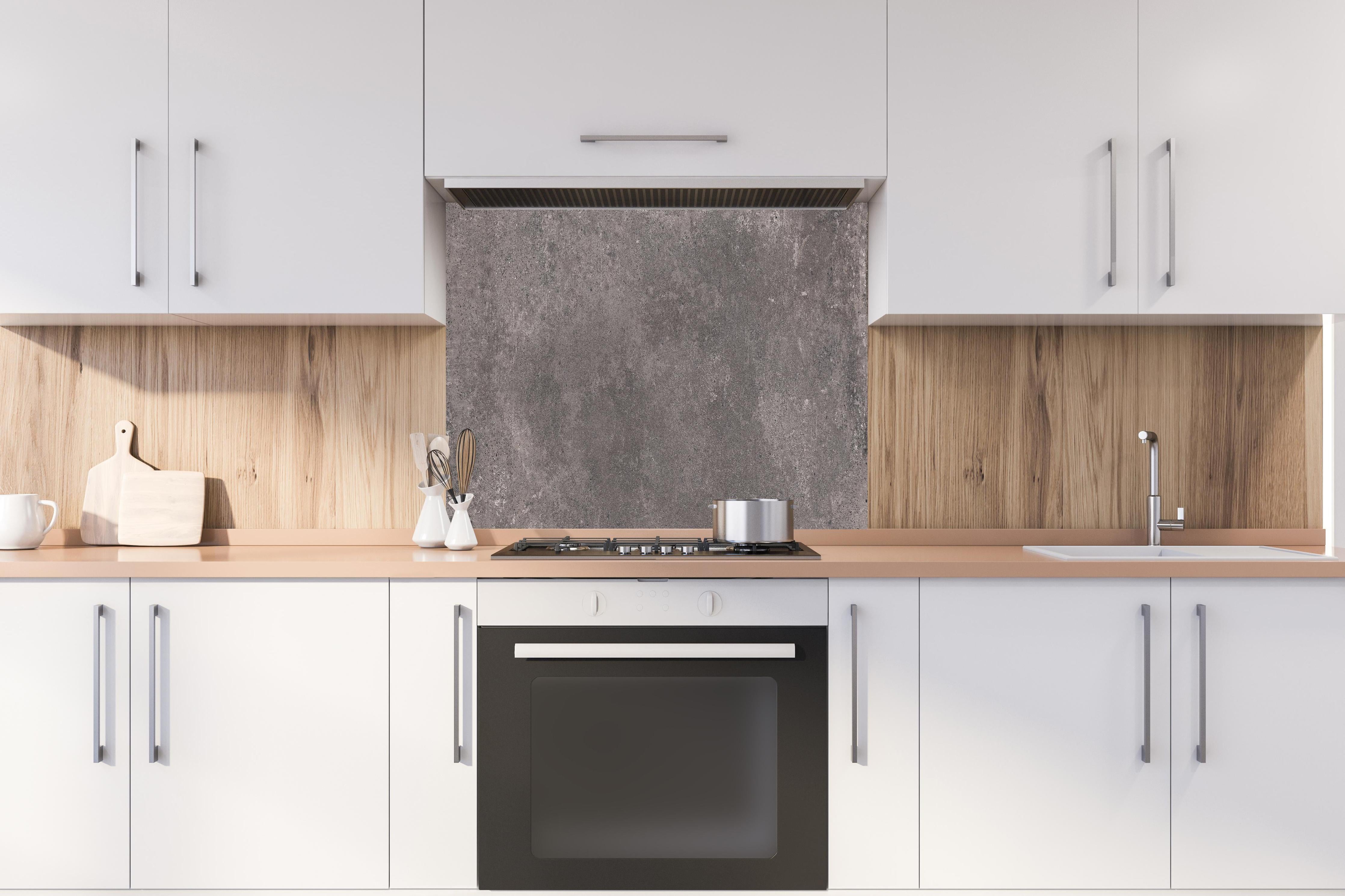 Spritzschutz - Bräunliche luxuriöse Marmortextur hinter einem Cerankochfeld zwischen Holz-Kochutensilien
