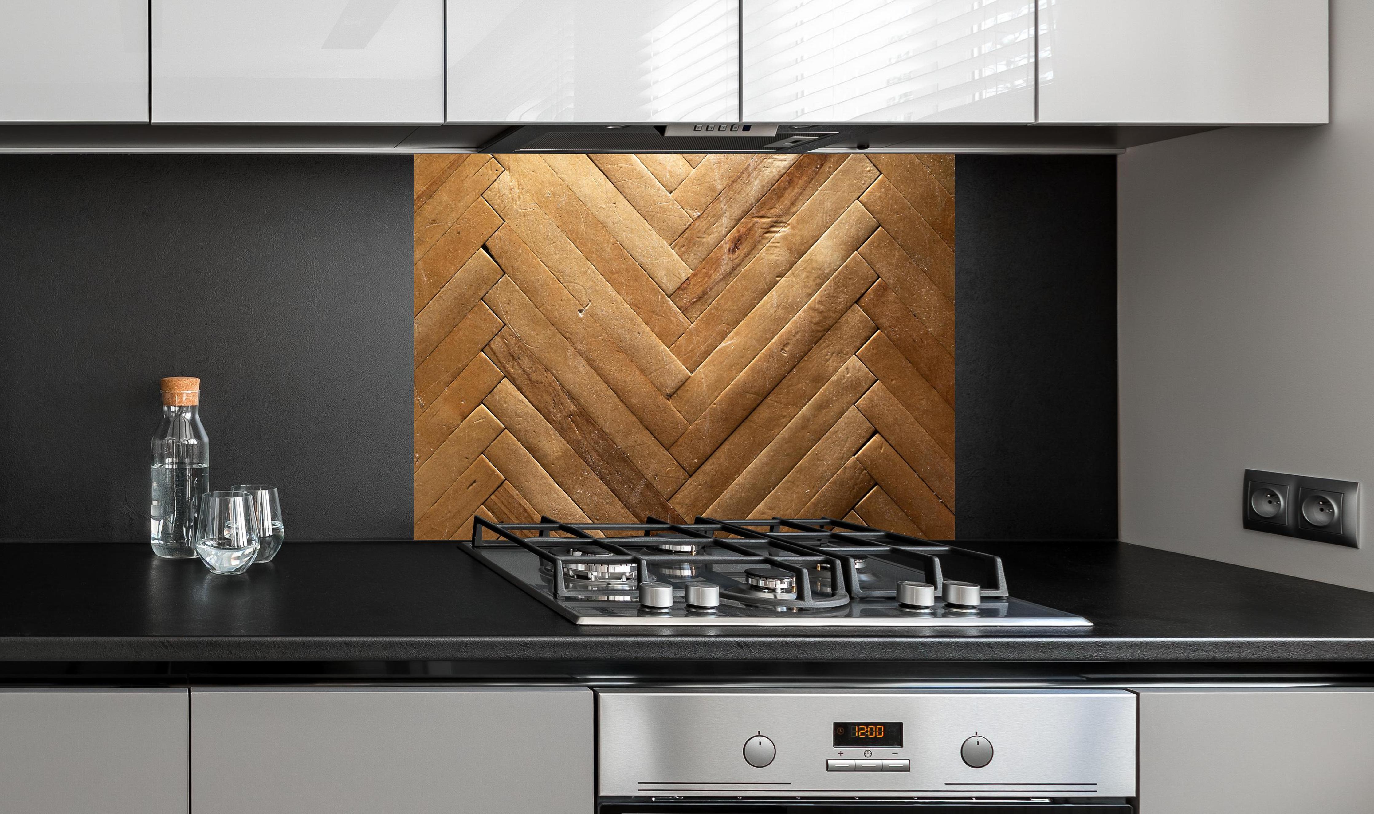 Spritzschutz - Bräunliches Holzbrett Muster hinter einem Cerankochfeld zwischen Holz-Kochutensilien
