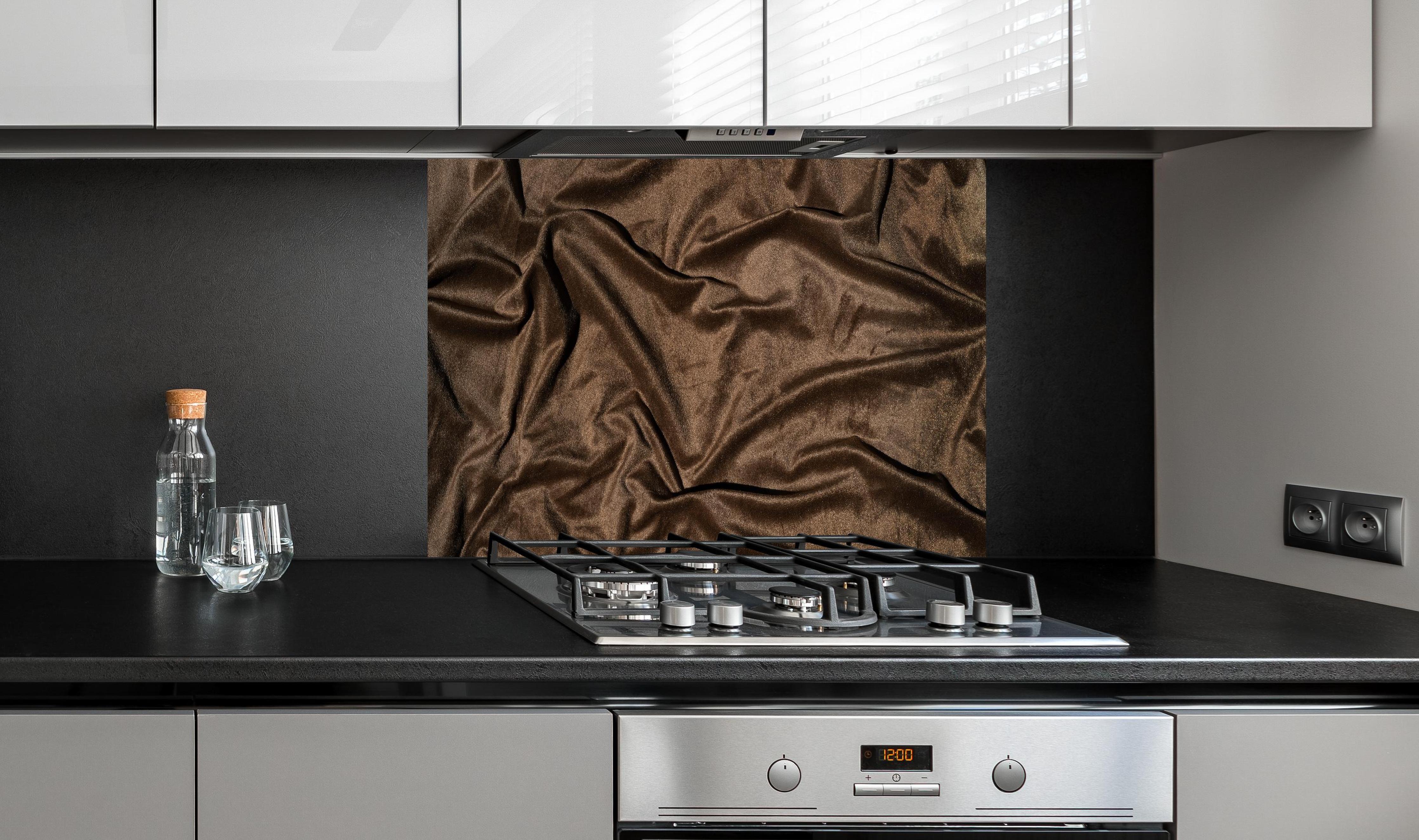 Spritzschutz - Braune Satin Seide hinter einem Cerankochfeld zwischen Holz-Kochutensilien
