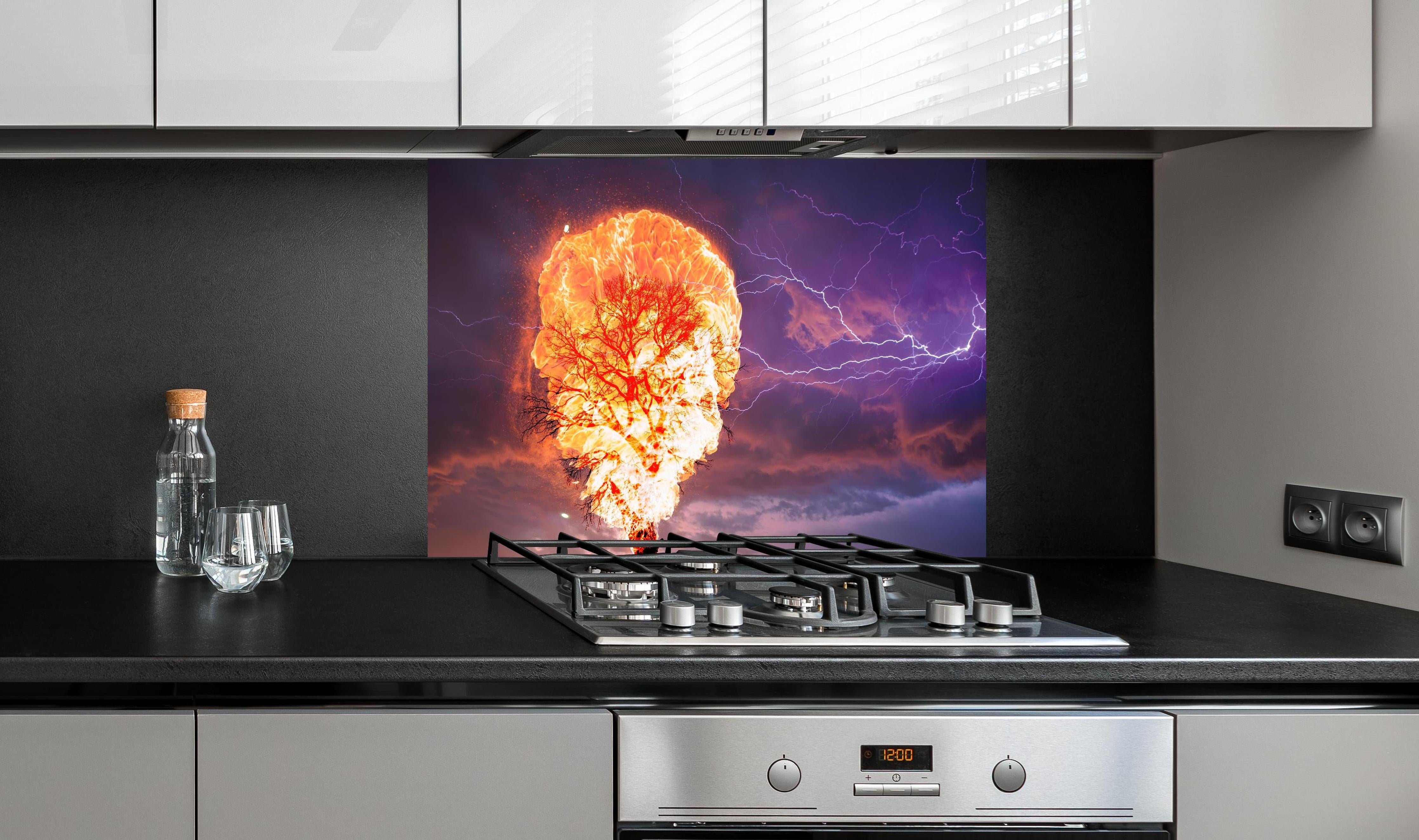 Spritzschutz - Brennender Baum bei Gewittersturm hinter einem Cerankochfeld zwischen Holz-Kochutensilien
