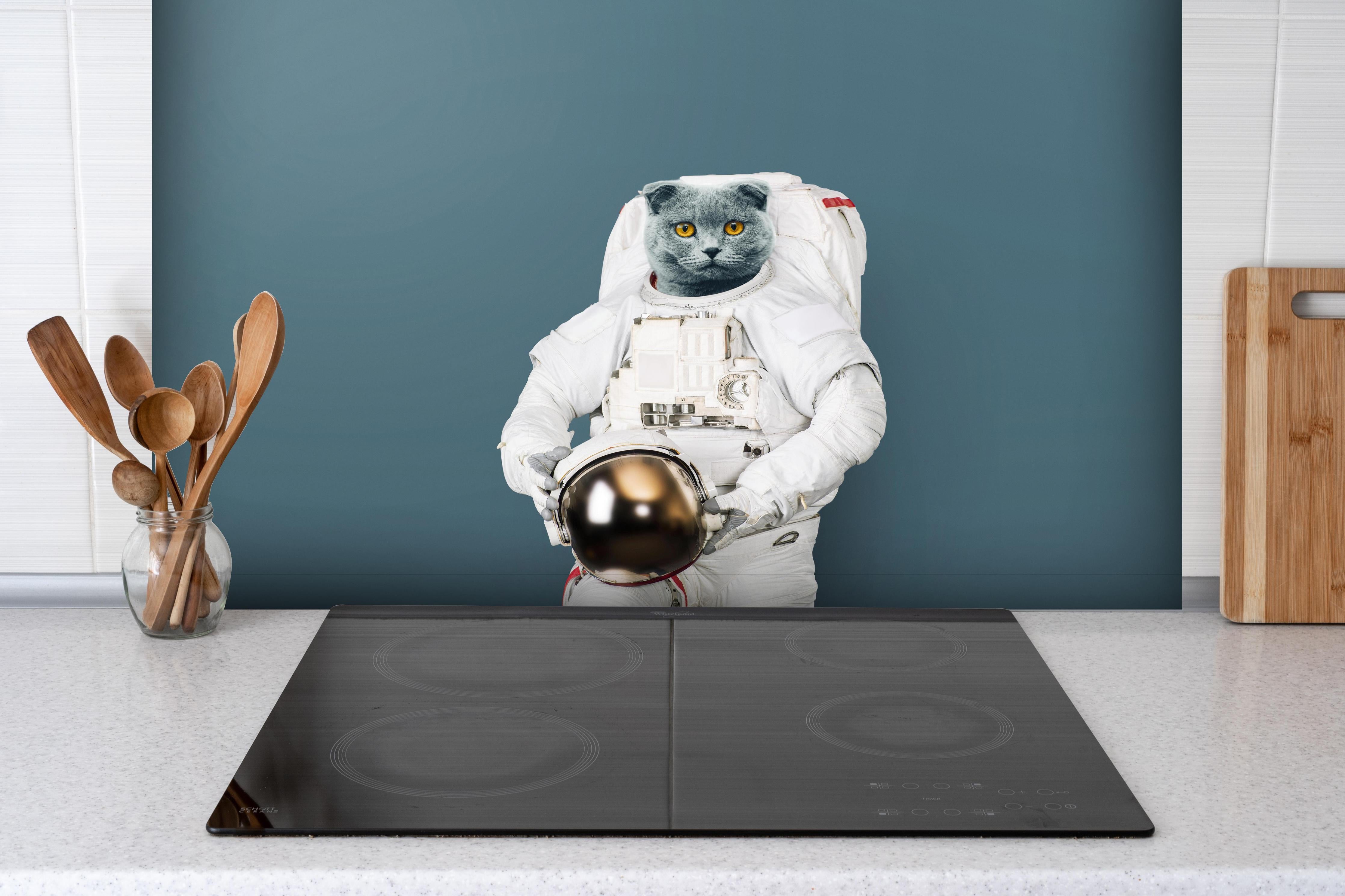 Spritzschutz - Britischer Katzen-Astronaut mit Helm hinter einem Cerankochfeld zwischen Holz-Kochutensilien
