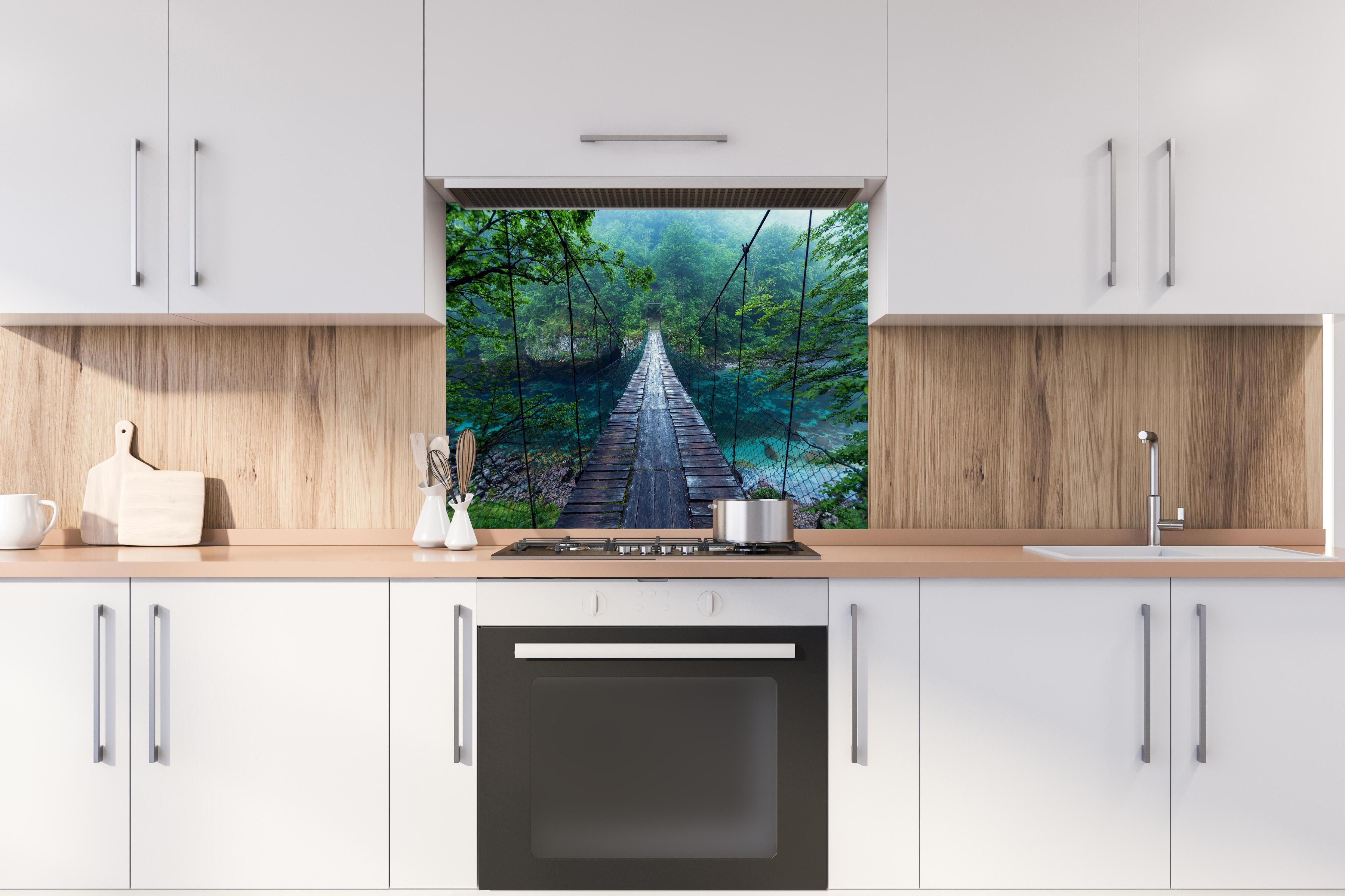 Spritzschutz - Brücke über Kristallklarem Fluss hinter einem Cerankochfeld zwischen Holz-Kochutensilien
