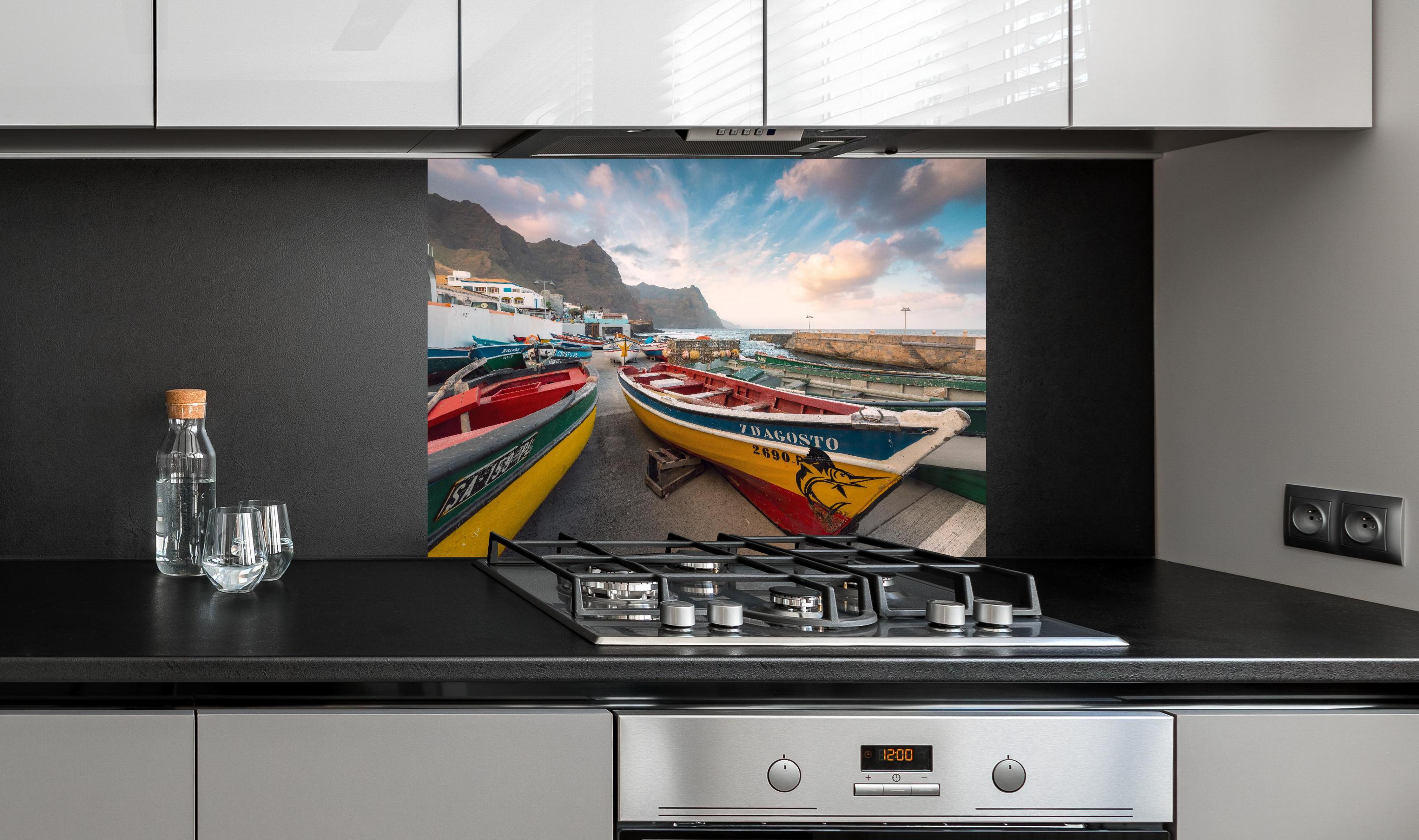 Spritzschutz - Bunte Boote am Strand hinter einem Cerankochfeld zwischen Holz-Kochutensilien
