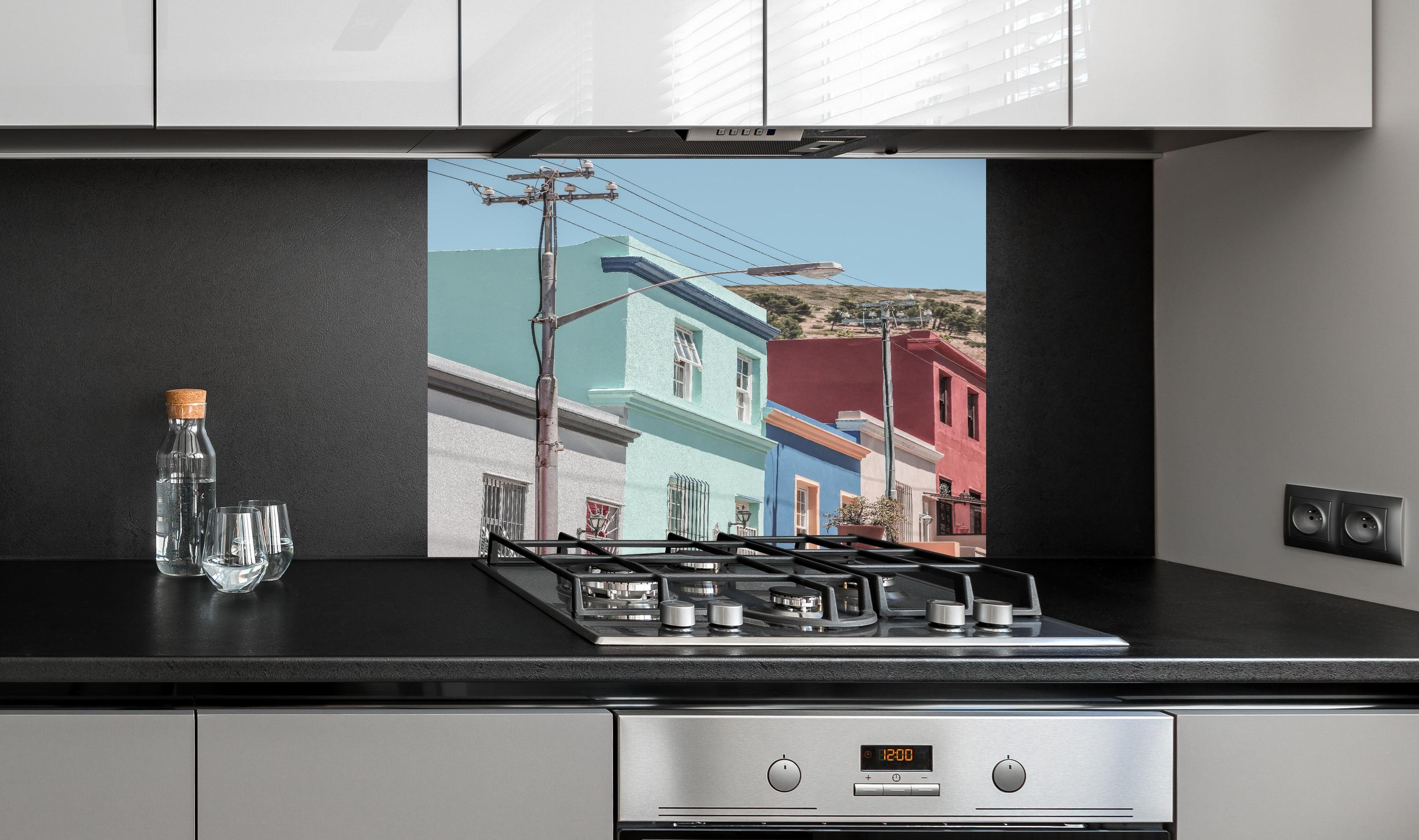 Spritzschutz - Bunte Gebäude - Bo-Kaap, Kapstadt hinter einem Cerankochfeld zwischen Holz-Kochutensilien
