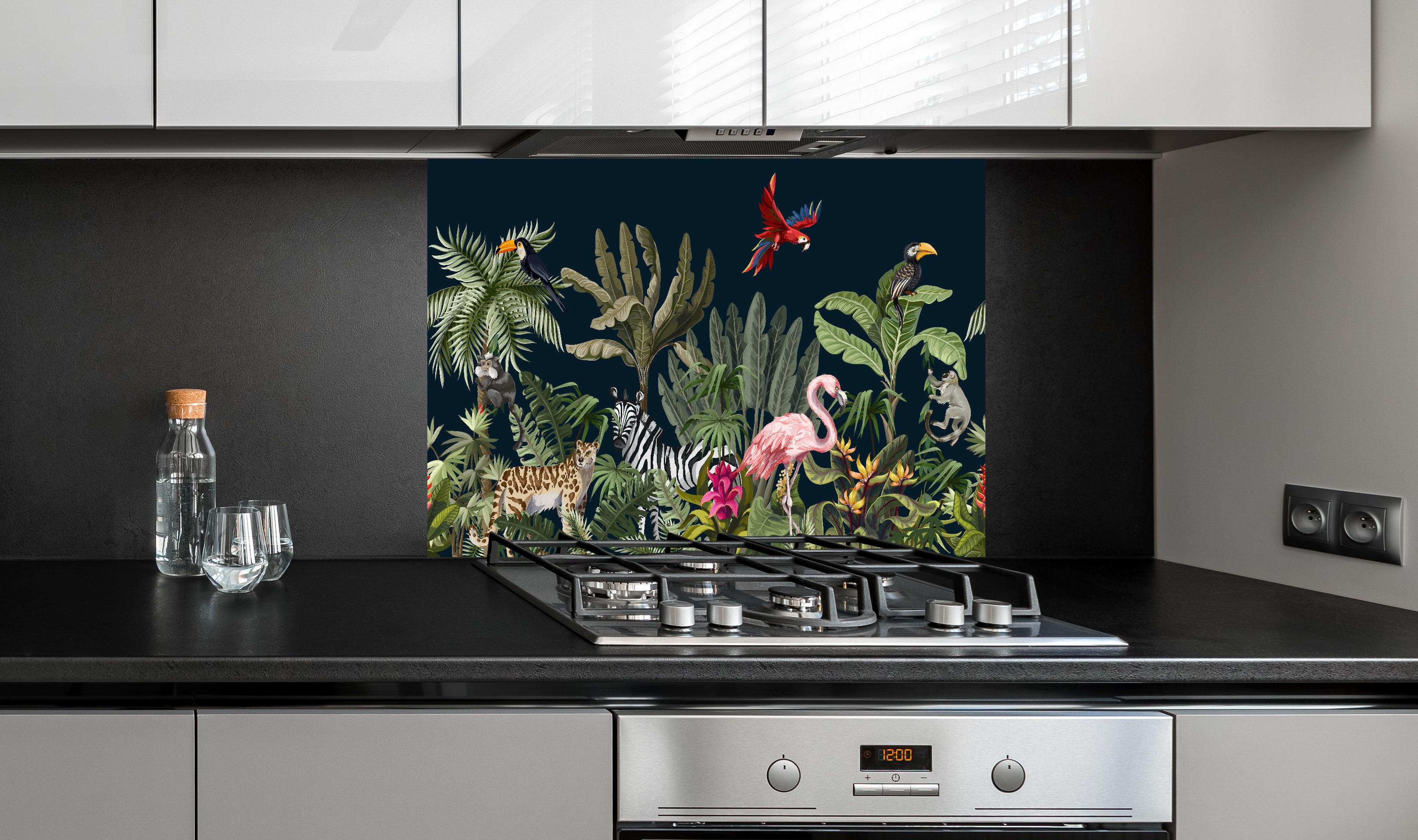 Spritzschutz - Buntes Dschungel Tiermuster Wandbild hinter einem Cerankochfeld zwischen Holz-Kochutensilien
