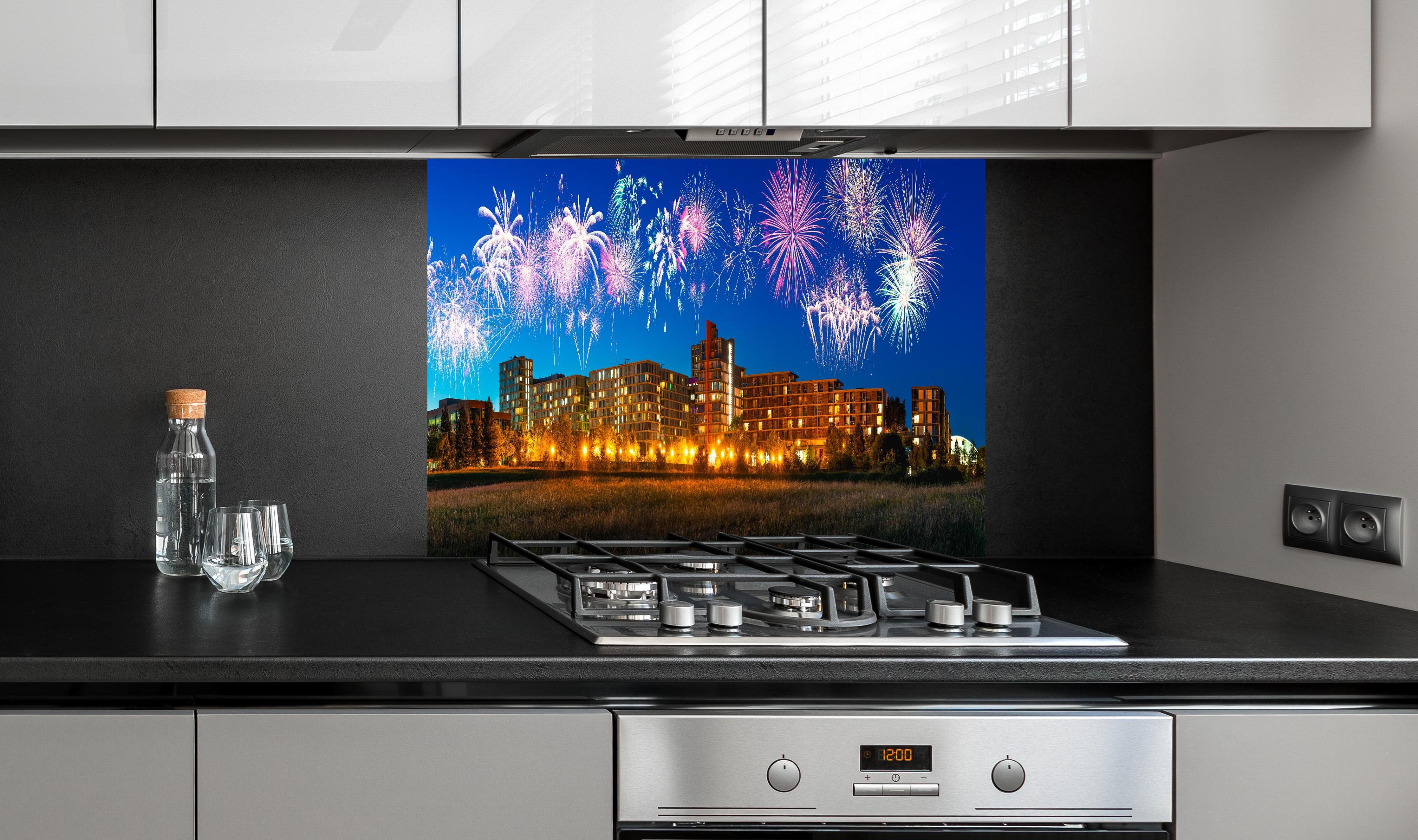 Spritzschutz - Buntes Feuerwerk Milton Keynes Skyline hinter einem Cerankochfeld zwischen Holz-Kochutensilien
