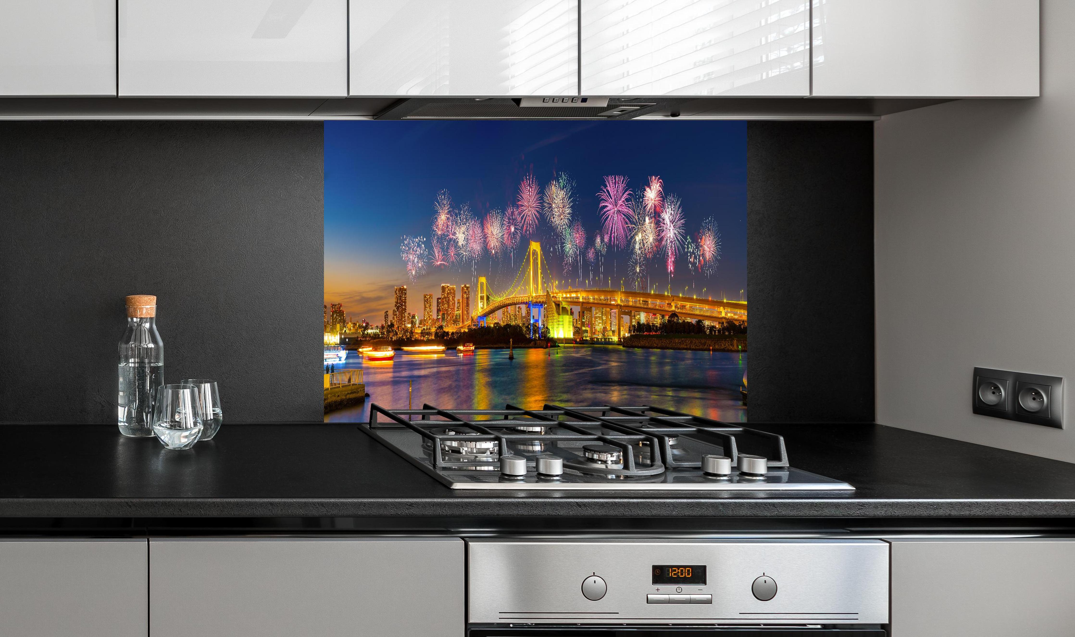 Spritzschutz - Buntes Feuerwerk Tokio Rainbow Bridge hinter einem Cerankochfeld zwischen Holz-Kochutensilien
