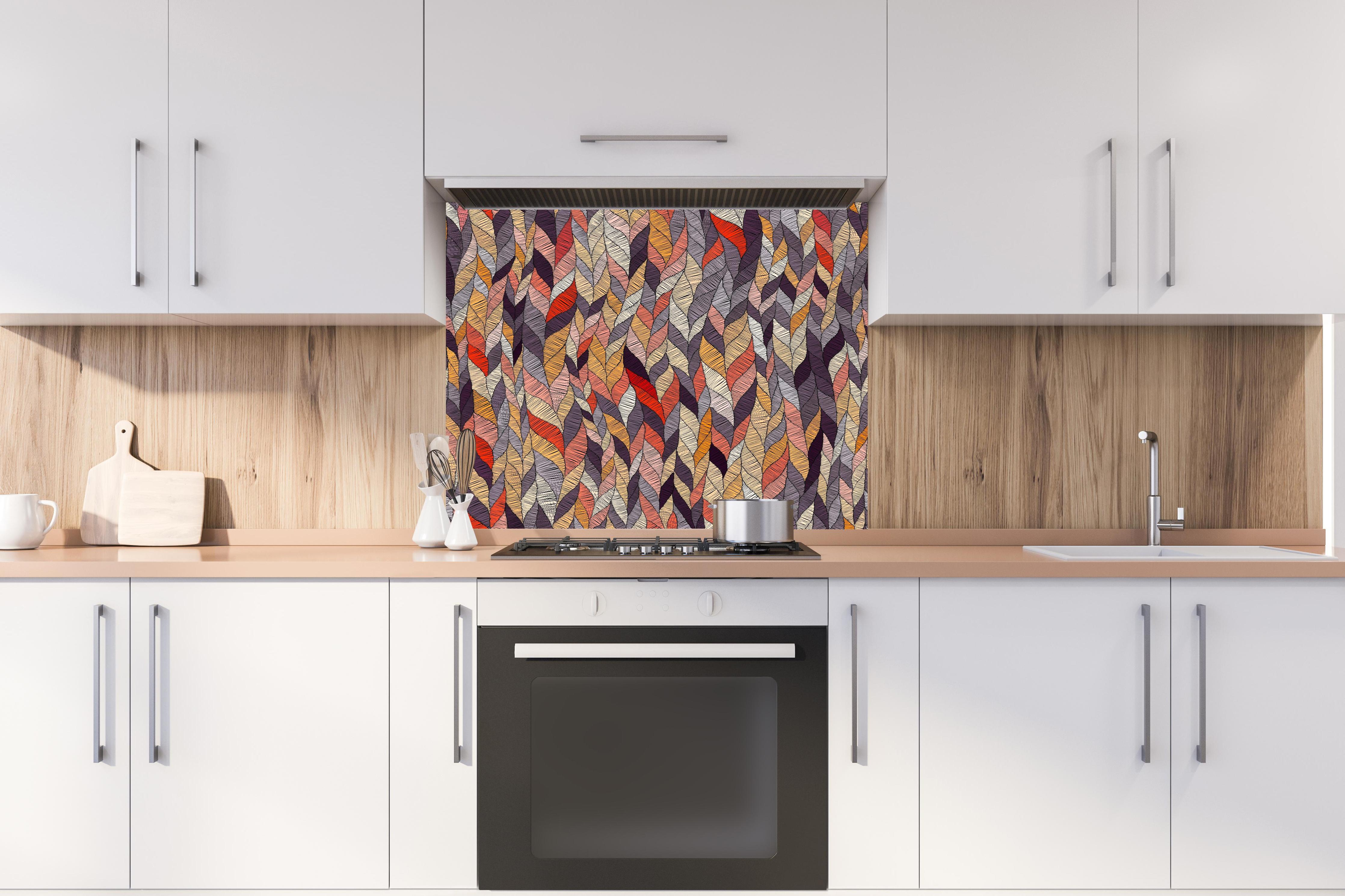 Spritzschutz - Buntes Textil Wellenmuster in Herbsttönen hinter einem Cerankochfeld zwischen Holz-Kochutensilien
