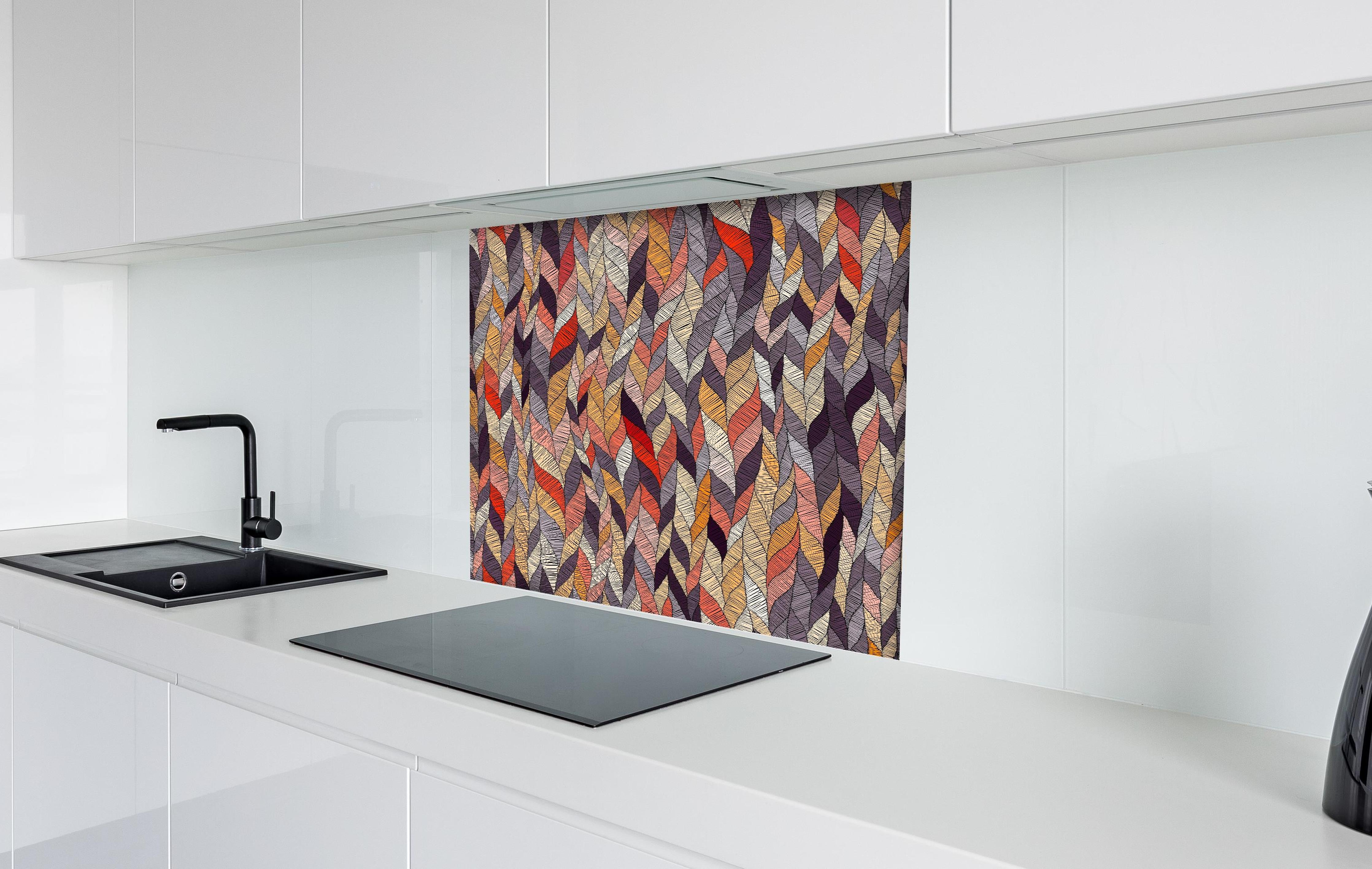 Spritzschutz - Buntes Textil Wellenmuster in Herbsttönen hinter einem Cerankochfeld zwischen Holz-Kochutensilien
