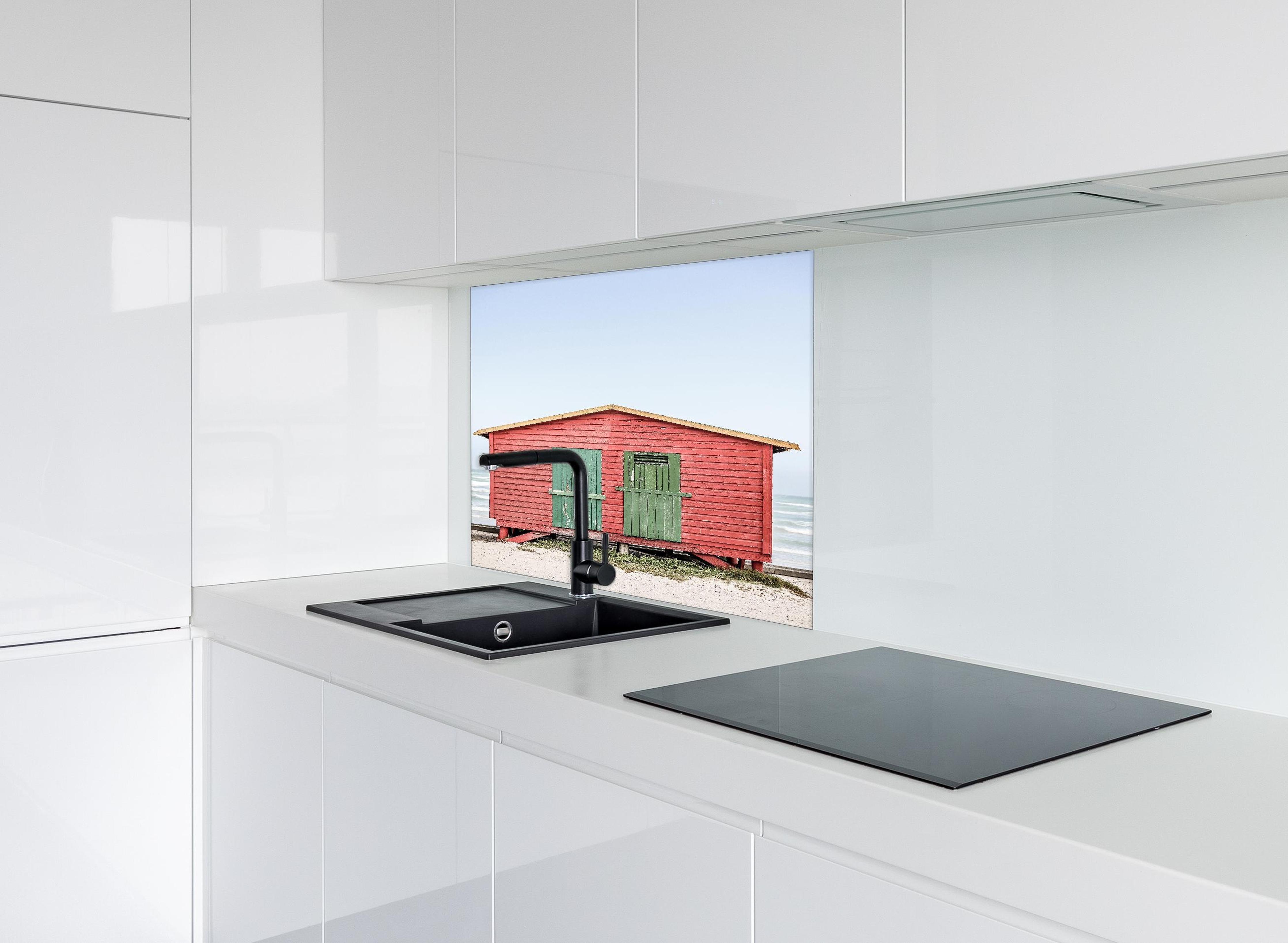Spritzschutz - Charmante rote Strandhütte Küstenblick hinter einem Cerankochfeld zwischen Holz-Kochutensilien
