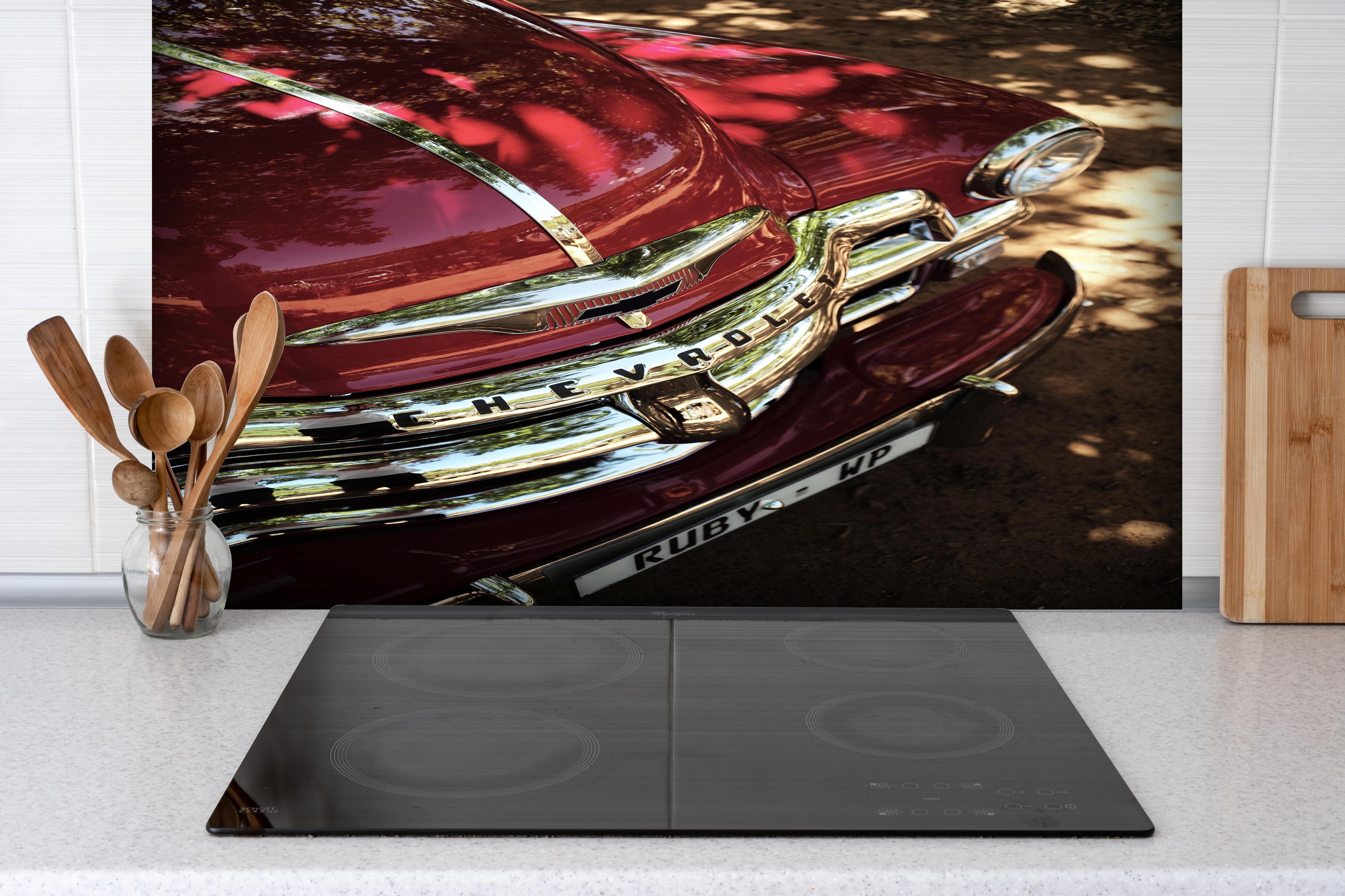 Spritzschutz - Chevrolet Nahaufnahme 3 hinter einem Cerankochfeld zwischen Holz-Kochutensilien
