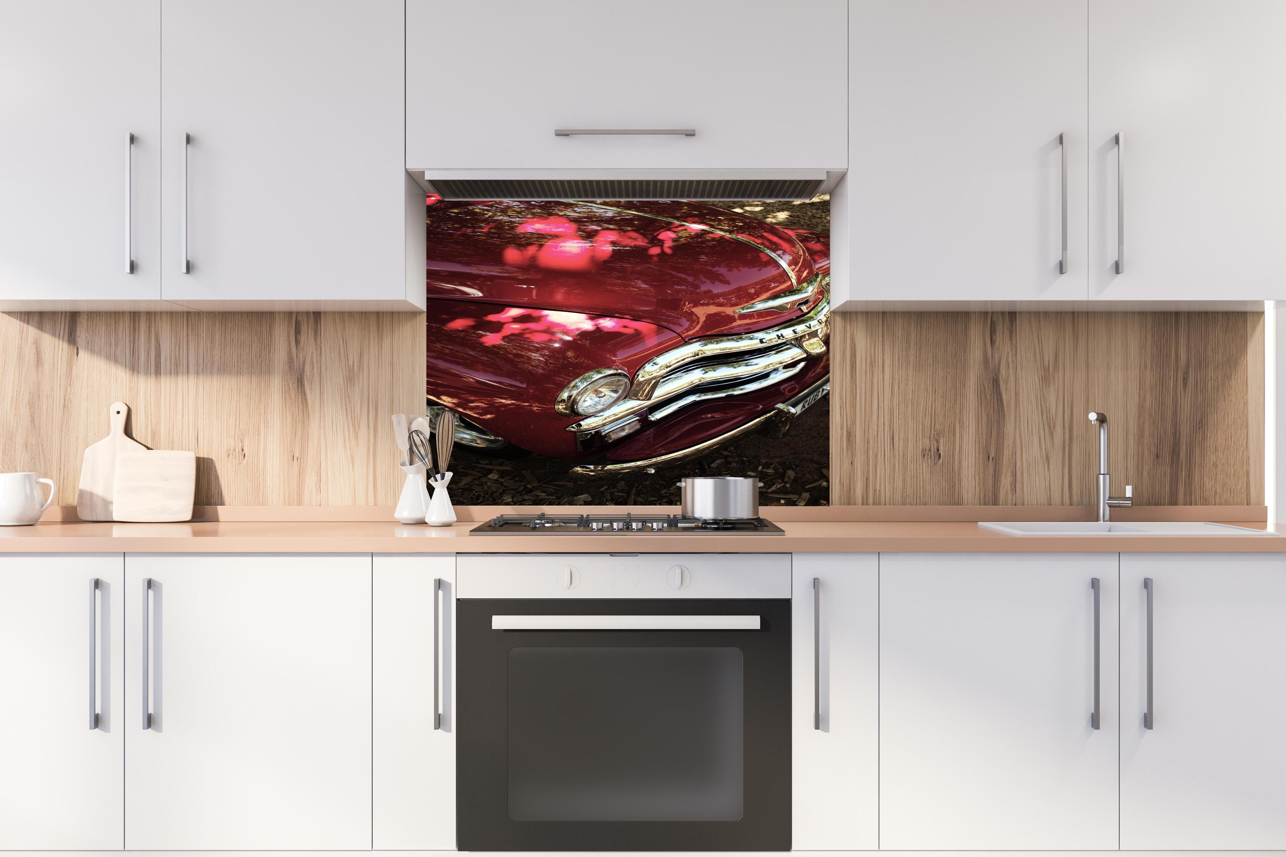 Spritzschutz - Chevrolet Nahaufnahme hinter einem Cerankochfeld zwischen Holz-Kochutensilien
