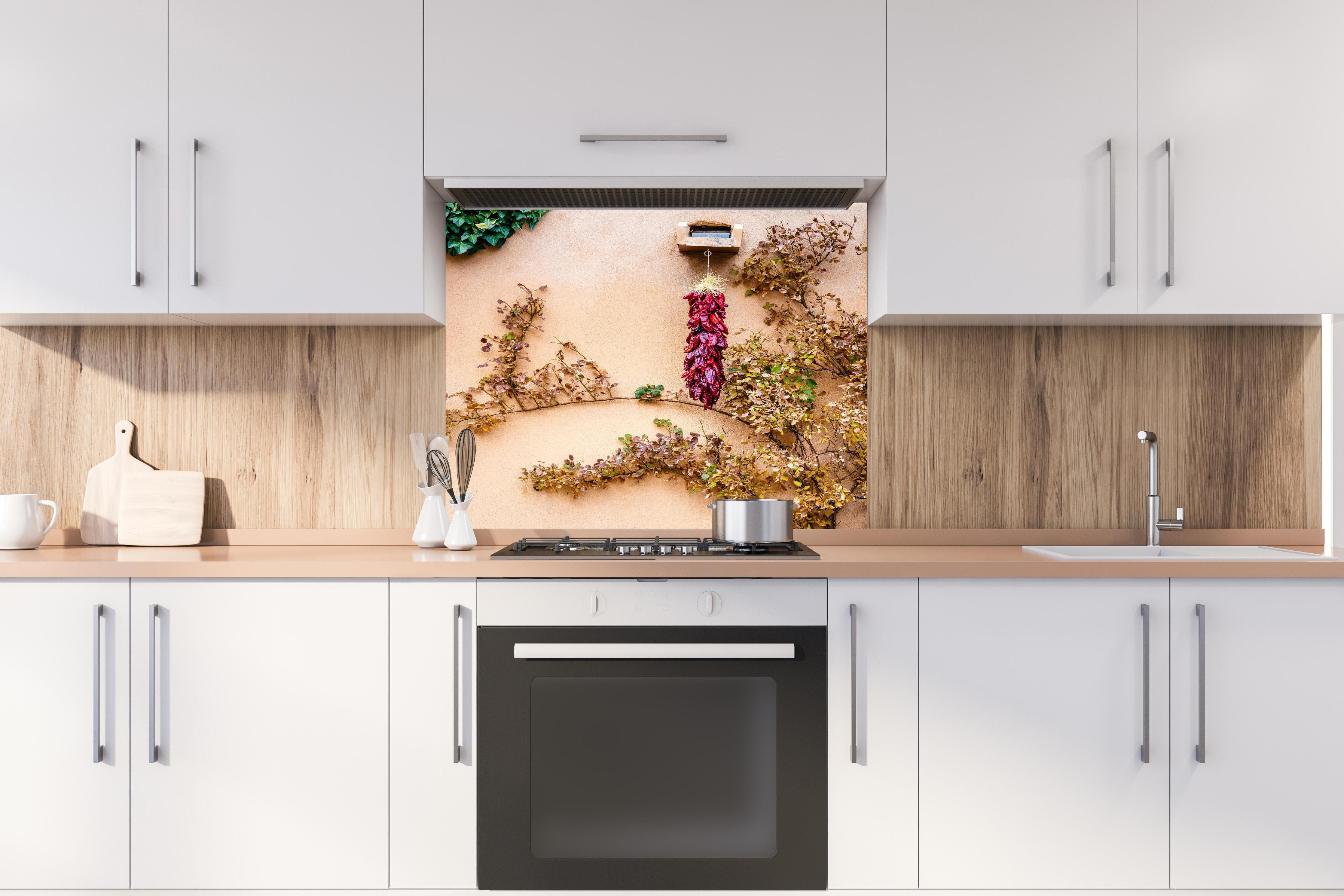 Spritzschutz - Chili Bündel - New Mexico hinter einem Cerankochfeld zwischen Holz-Kochutensilien
