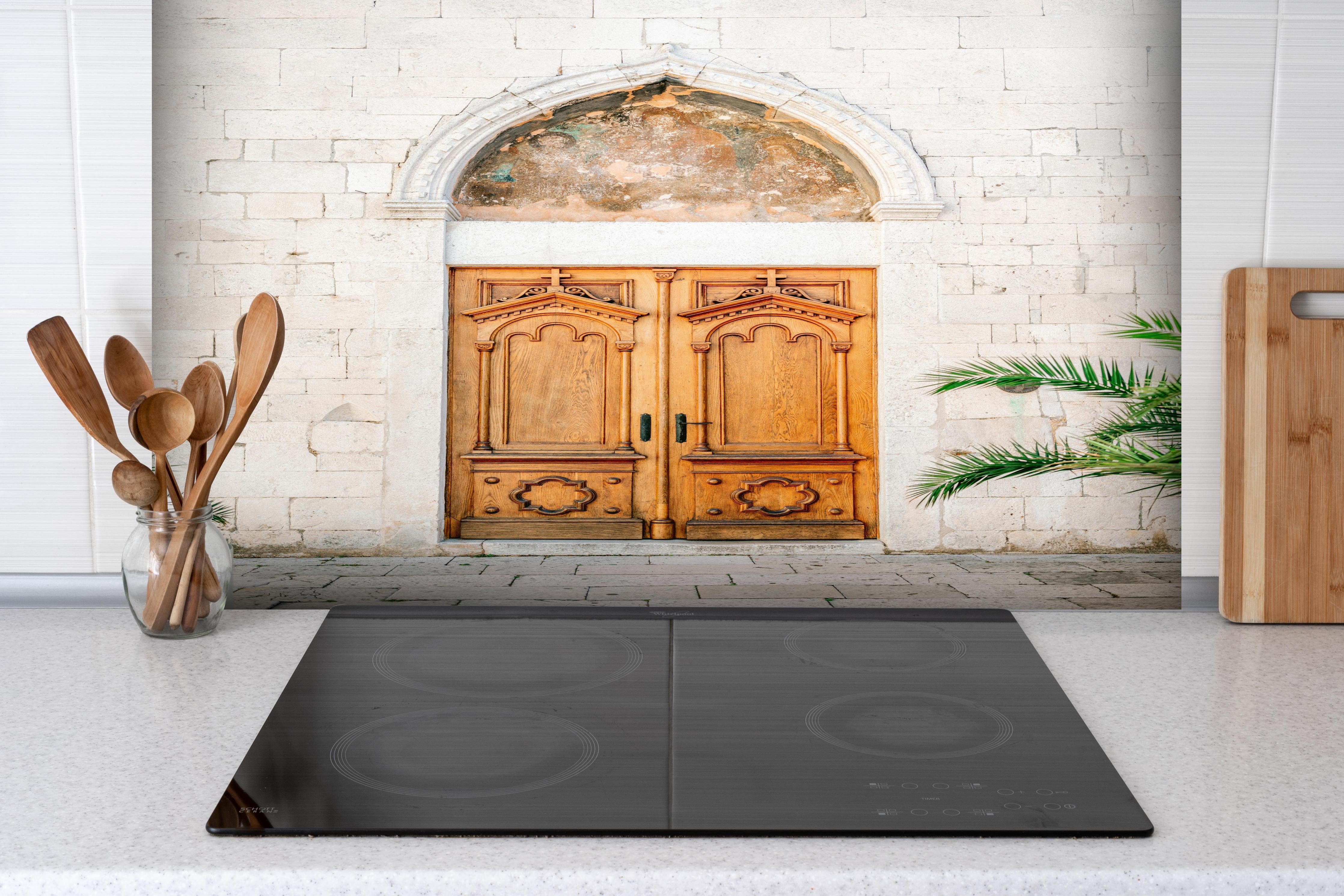 Spritzschutz - Croatian Door hinter einem Cerankochfeld zwischen Holz-Kochutensilien
