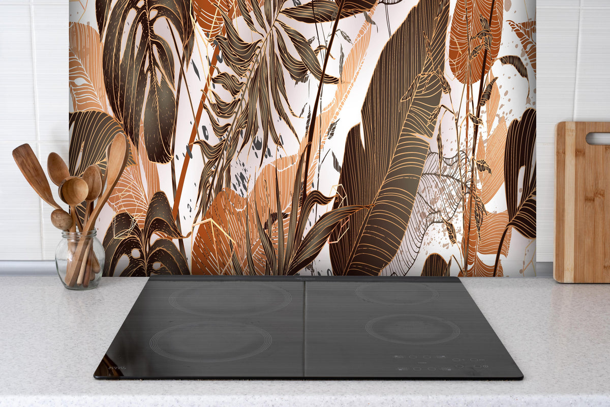Spritzschutz - Dekoratives Blatt-Design in warmen Erdtönen hinter einem Cerankochfeld zwischen Holz-Kochutensilien
