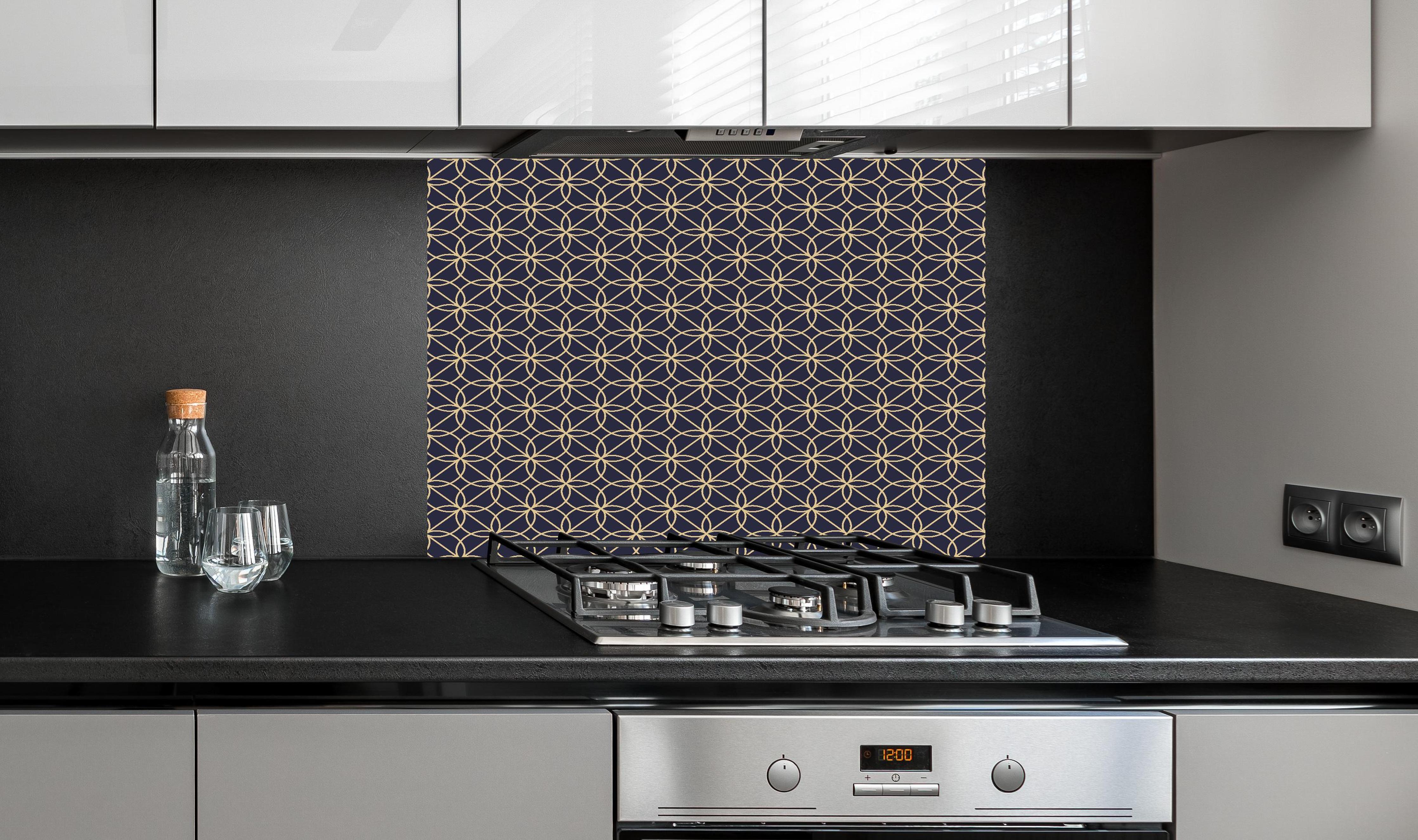 Spritzschutz - Dekoratives Blaues Geometrie-Muster hinter einem Cerankochfeld zwischen Holz-Kochutensilien
