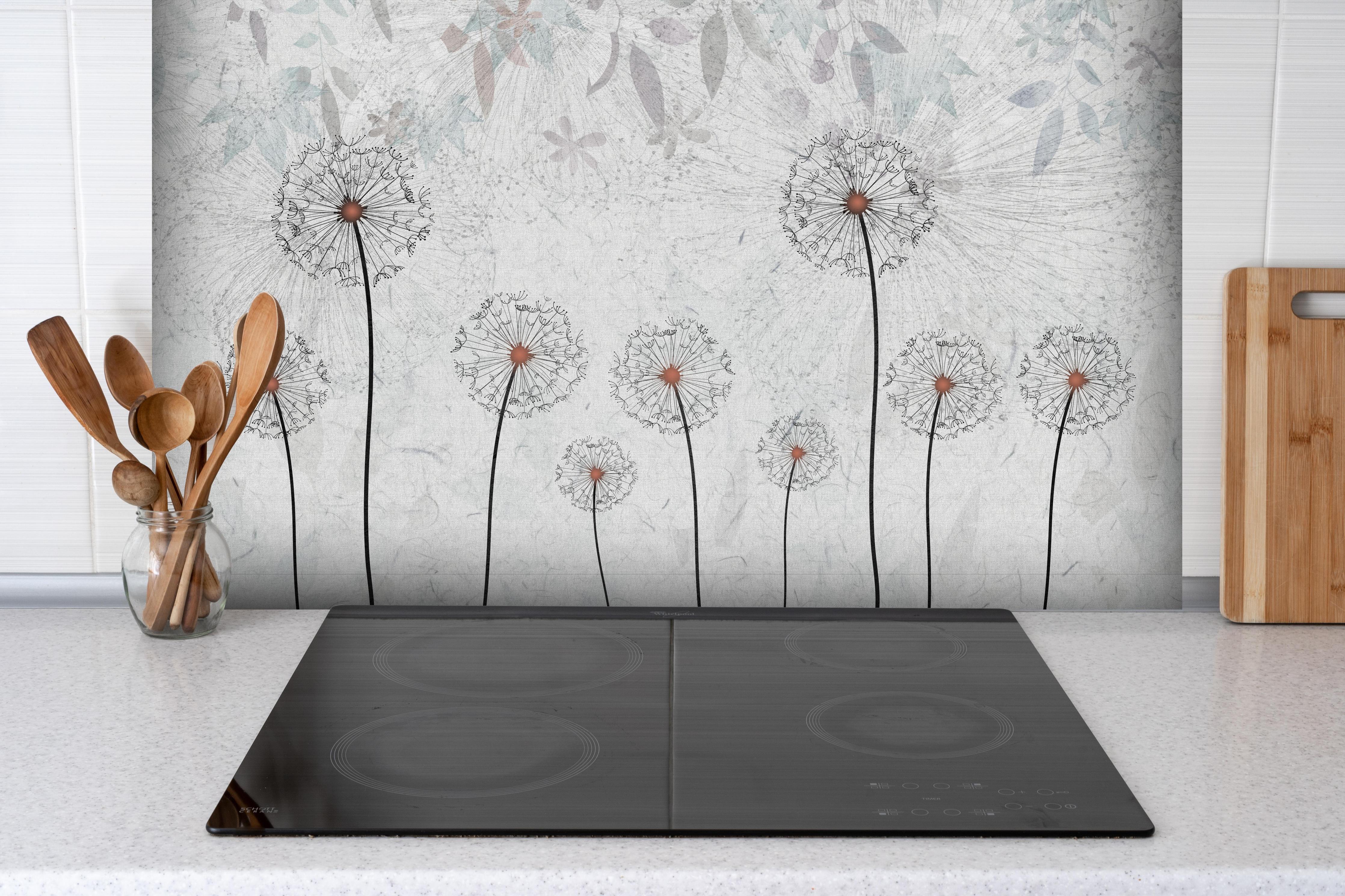 Spritzschutz - Dekoratives Löwenzahn Gemälde hinter einem Cerankochfeld zwischen Holz-Kochutensilien
