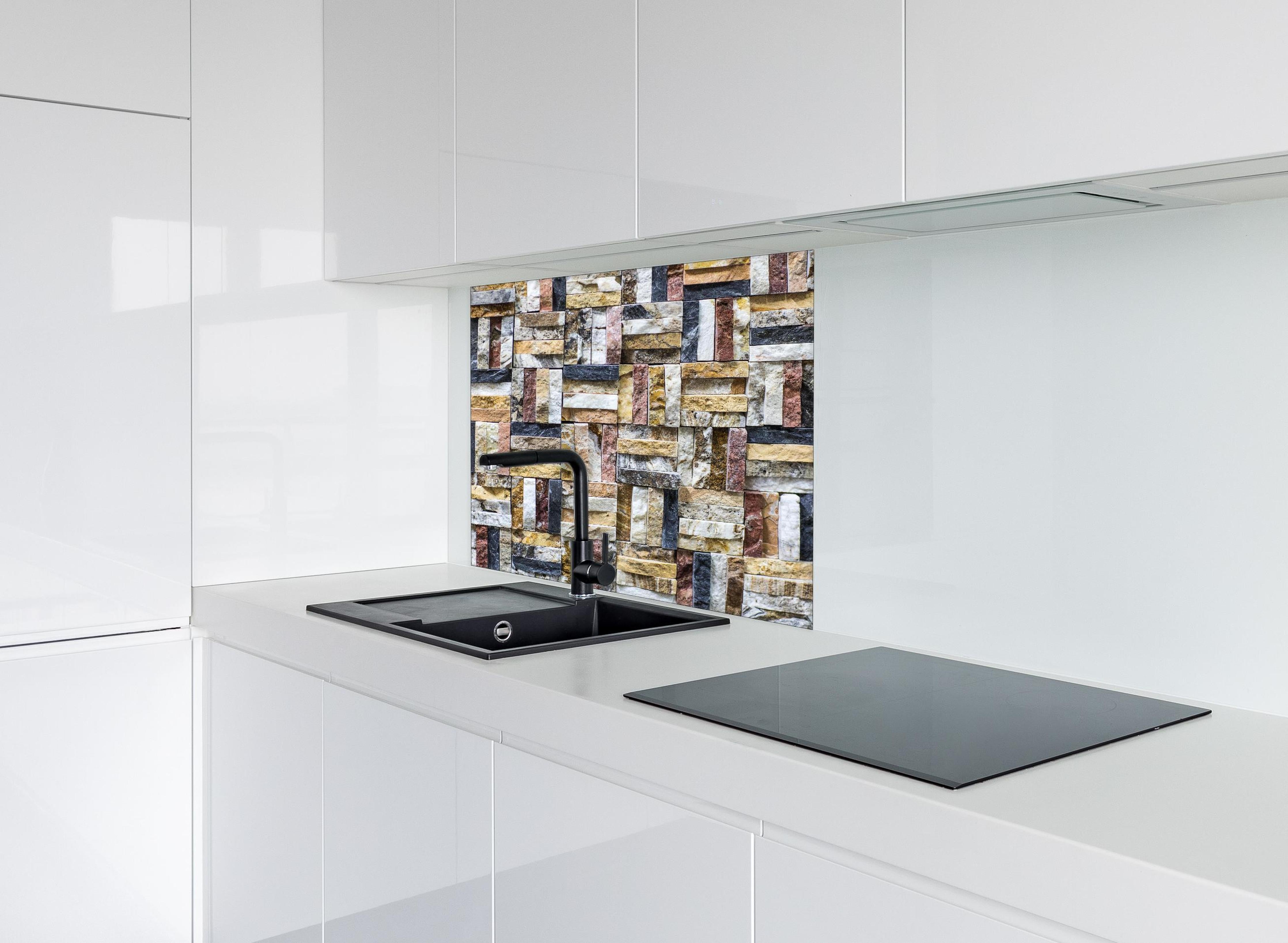 Spritzschutz - Dekoratives Wand Mosaik aus Naturstein hinter einem Cerankochfeld zwischen Holz-Kochutensilien
