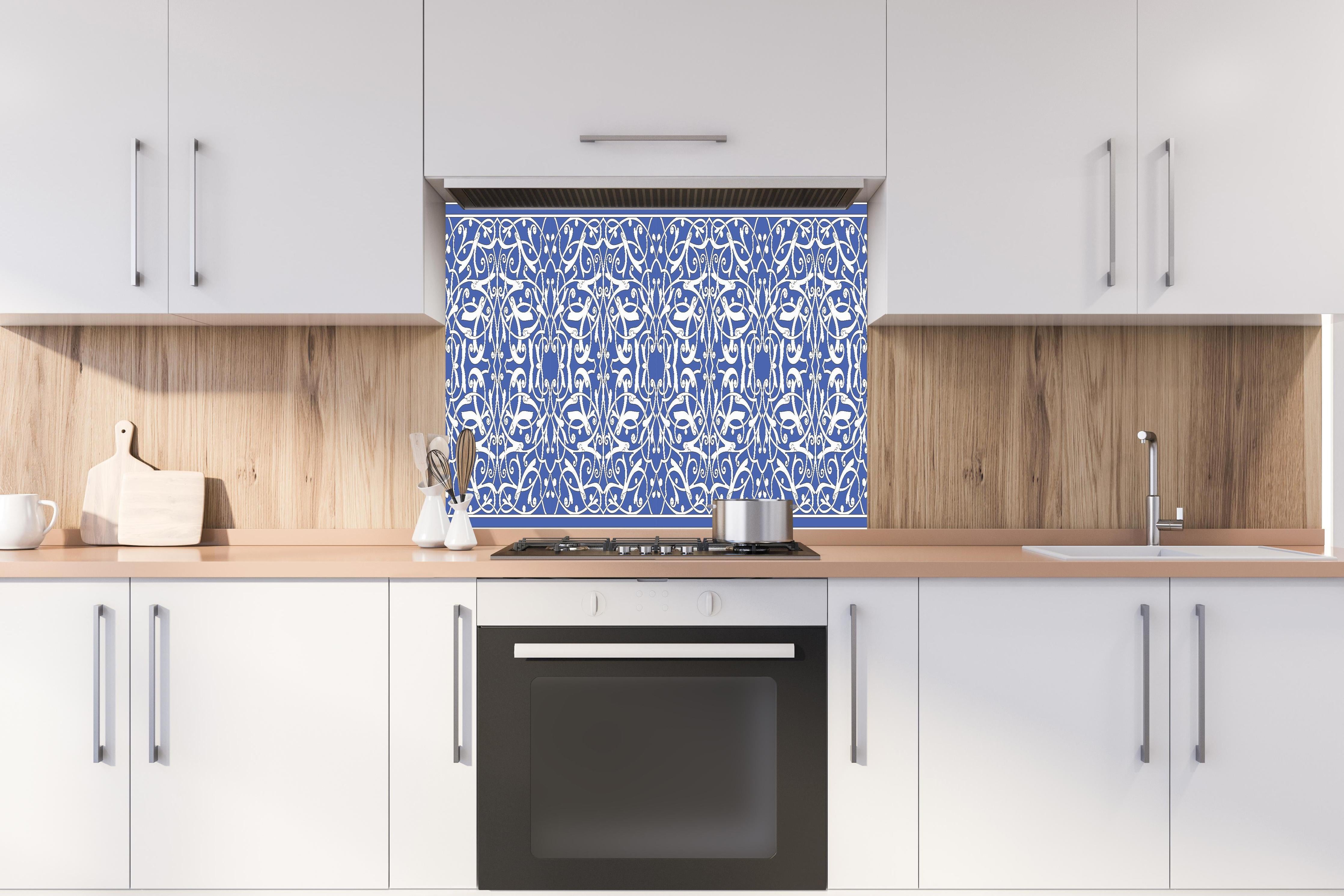 Spritzschutz - Dekoratives blau-weißes Ornament-Motiv hinter einem Cerankochfeld zwischen Holz-Kochutensilien
