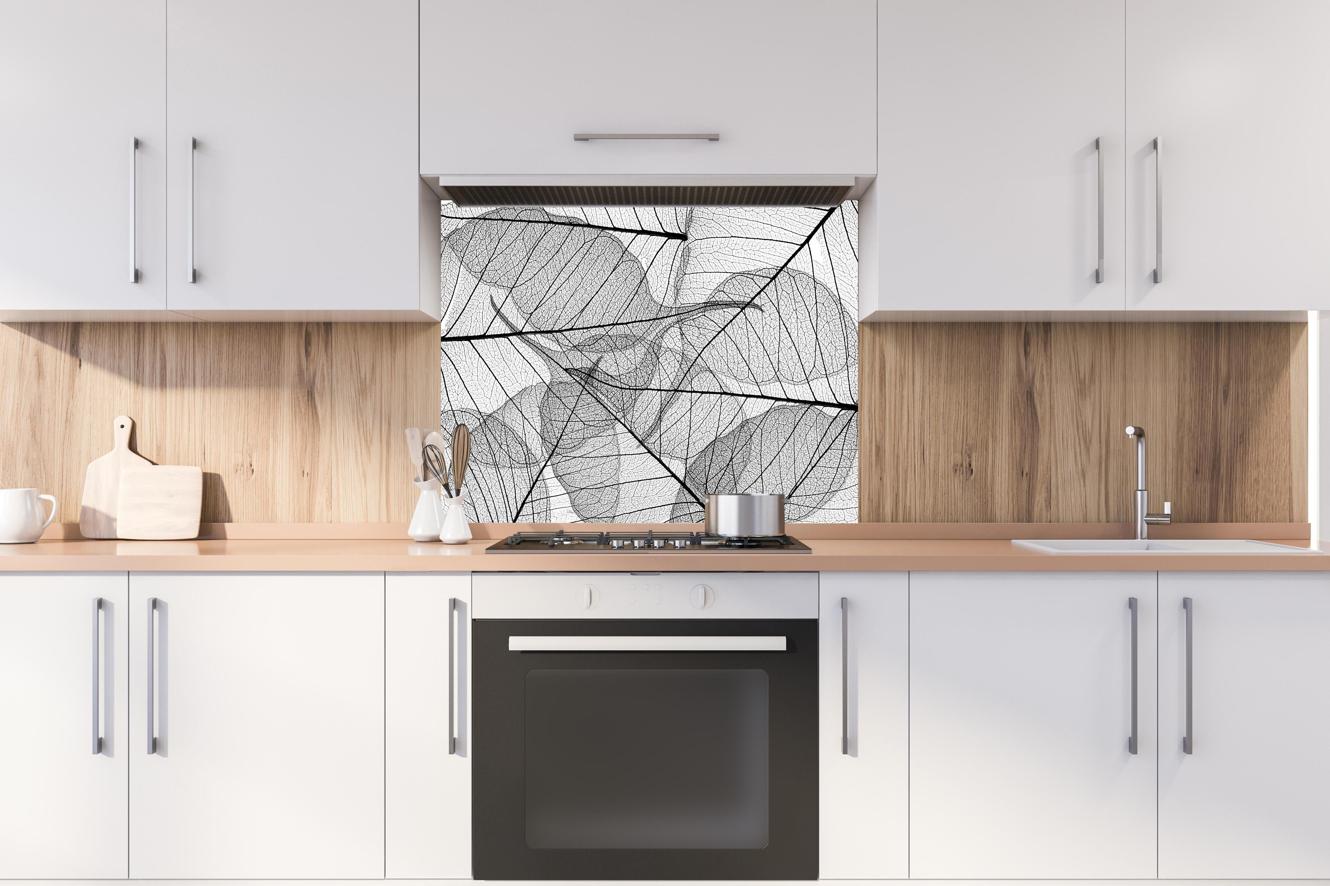 Spritzschutz - Detaillierte Schwarz-Weiße Laubtextur hinter einem Cerankochfeld zwischen Holz-Kochutensilien
