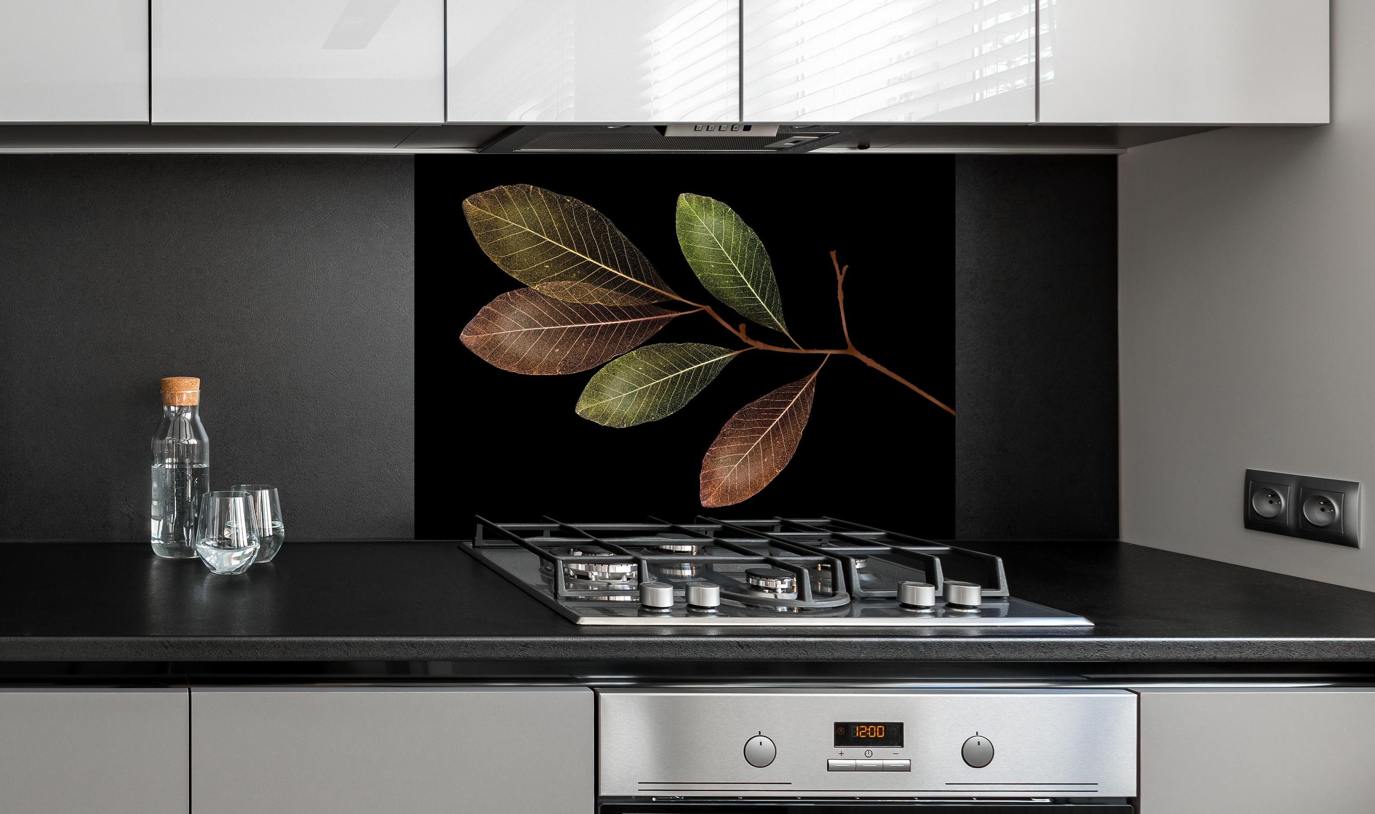 Spritzschutz - Detaillierte grün-braune Blattvenen Struktur hinter einem Cerankochfeld zwischen Holz-Kochutensilien
