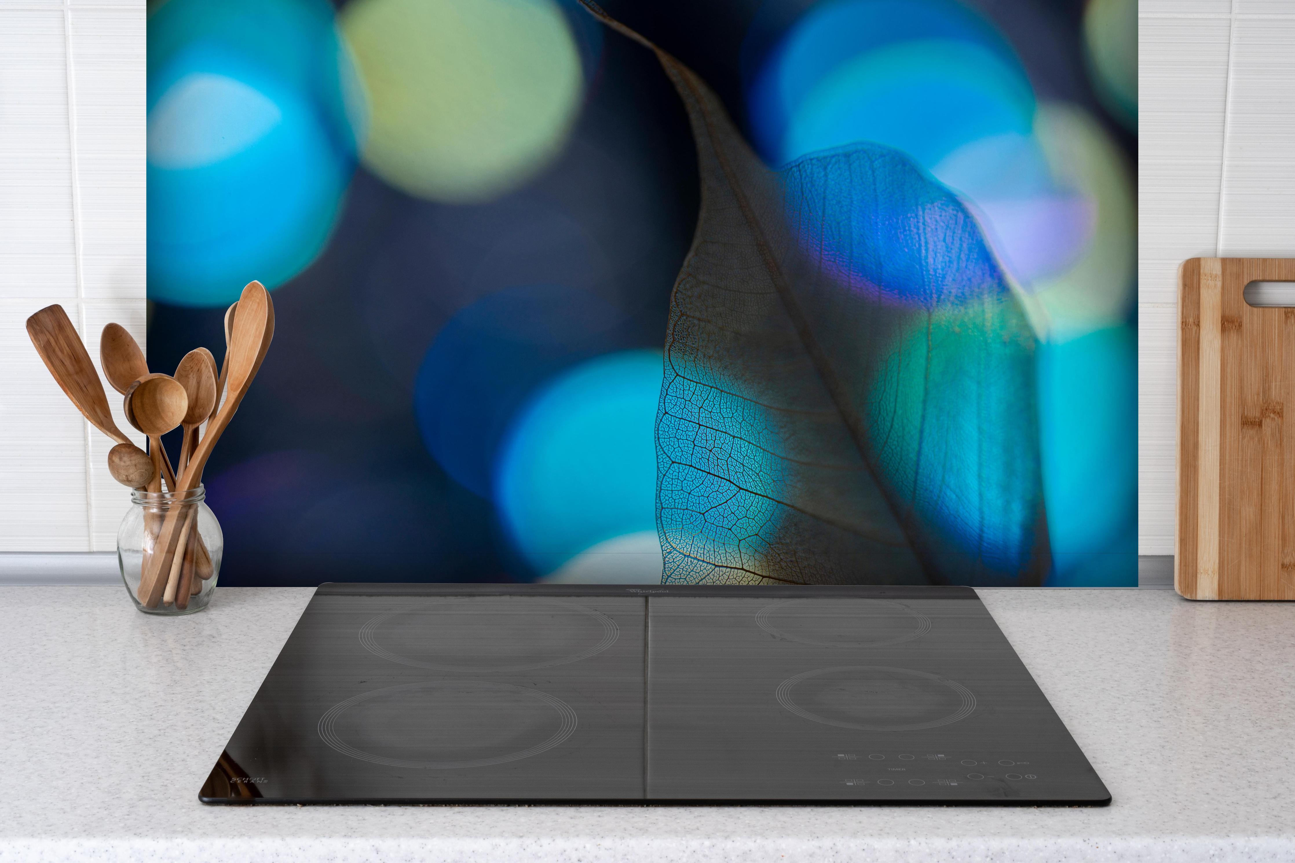 Spritzschutz - Detailreiche Blattader-Textur mit Farbspiel hinter einem Cerankochfeld zwischen Holz-Kochutensilien
