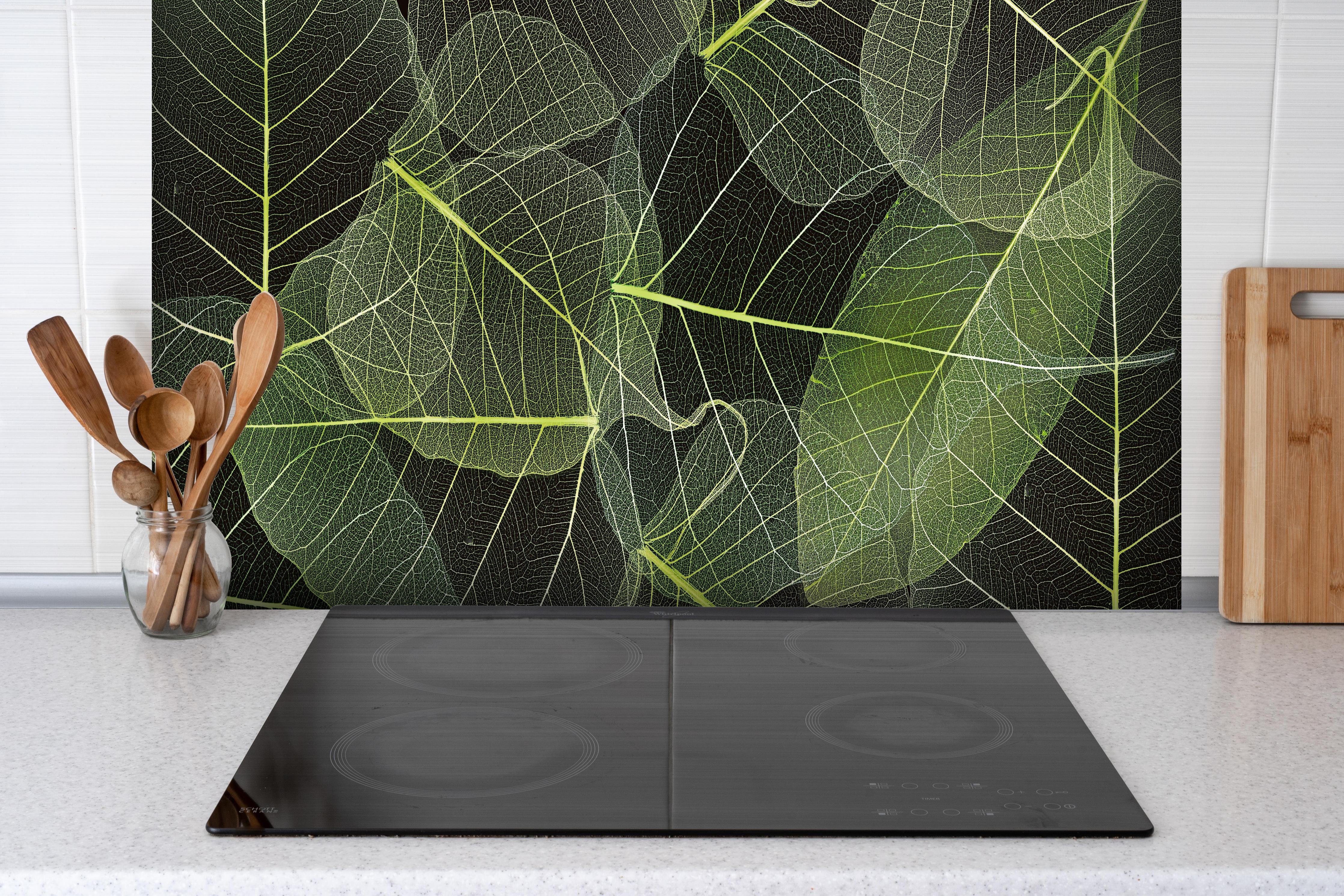 Spritzschutz - Detailreiche Blattadern Makroaufnahme hinter einem Cerankochfeld zwischen Holz-Kochutensilien
