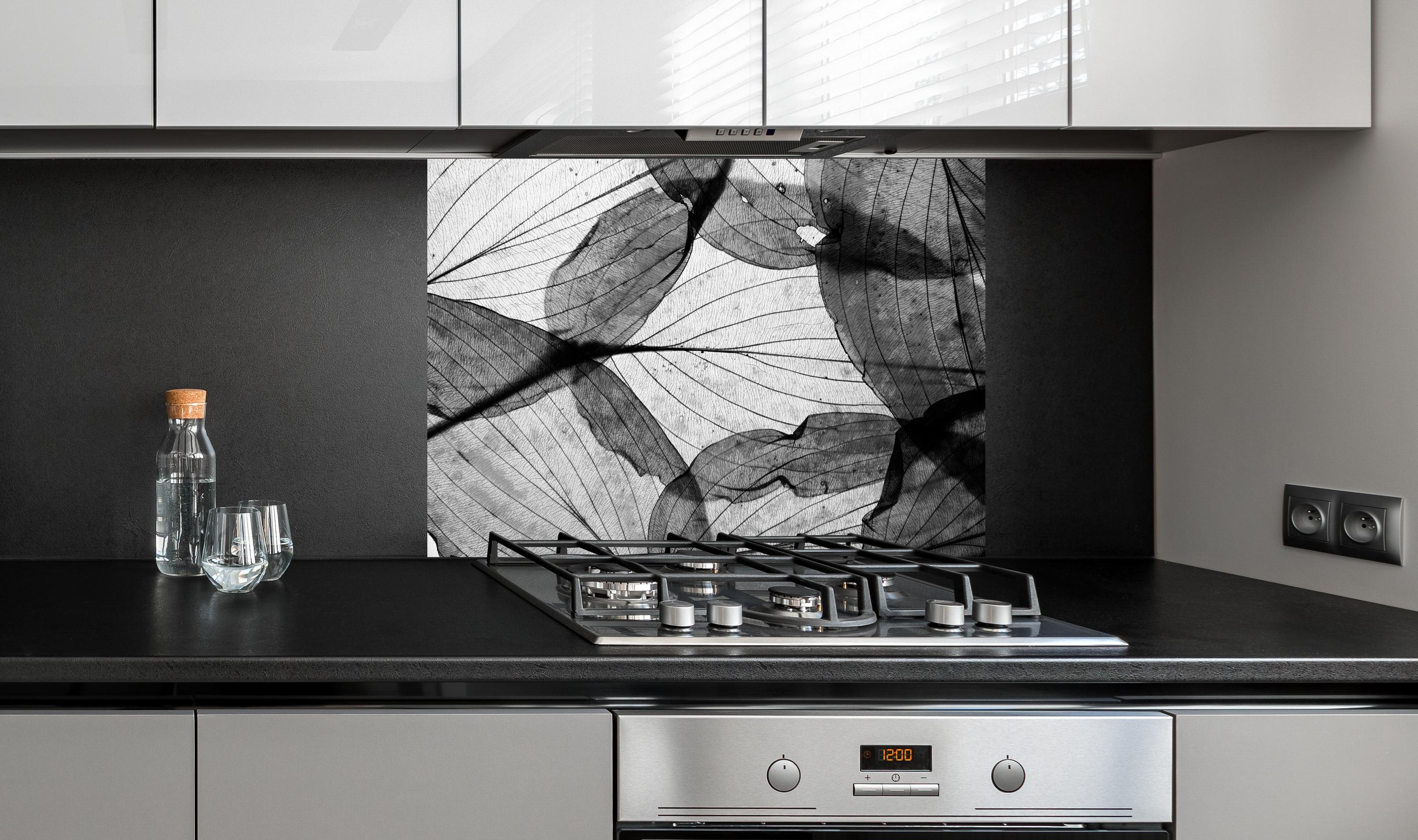 Spritzschutz - Detailreiche Schwarz-Weiße Laubtextur hinter einem Cerankochfeld zwischen Holz-Kochutensilien
