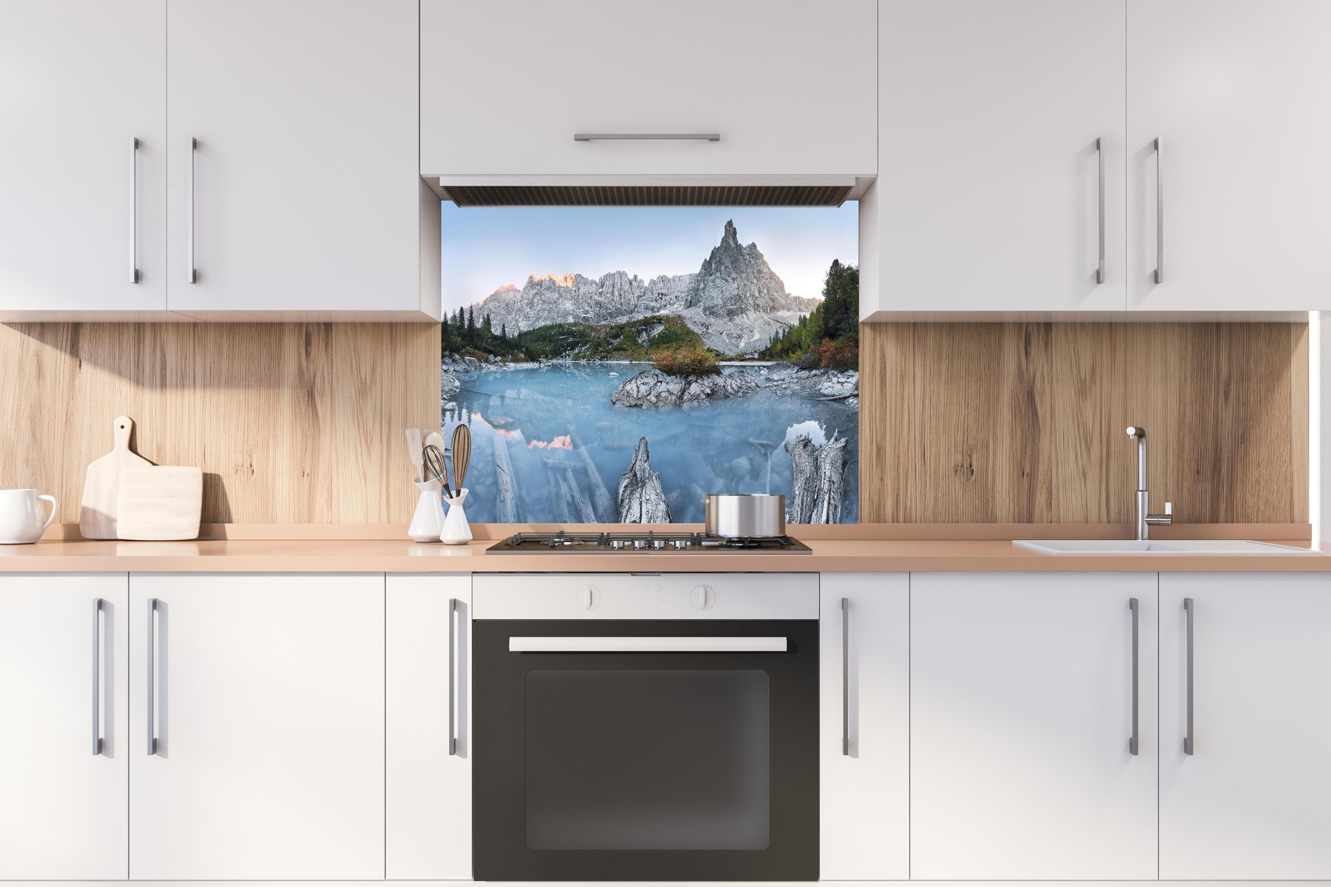 Spritzschutz - Dolomiten Seelandschaft im Abendlicht hinter einem Cerankochfeld zwischen Holz-Kochutensilien
