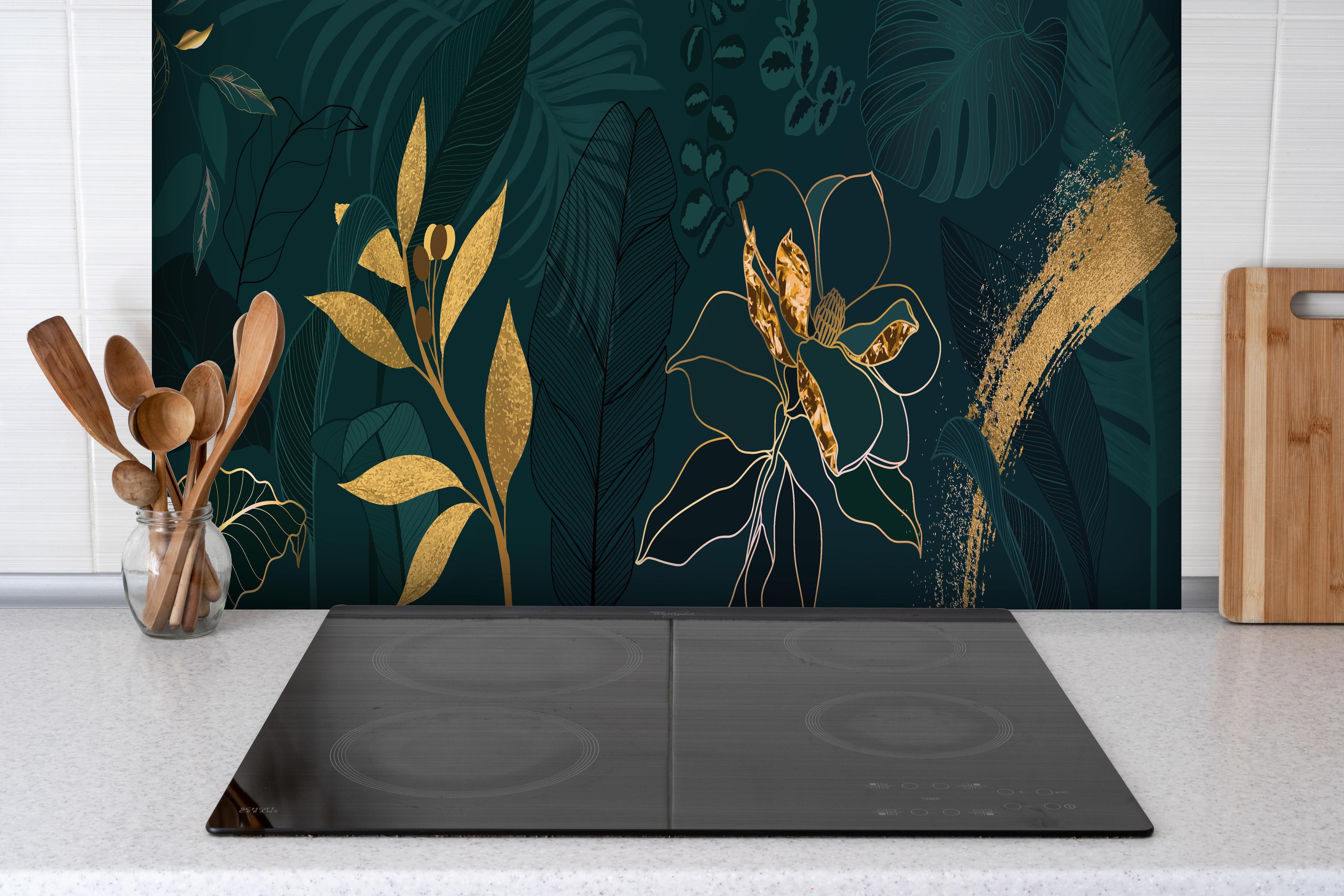 Spritzschutz - Dschungelmotive mit Goldlinien-Kunst hinter einem Cerankochfeld zwischen Holz-Kochutensilien
