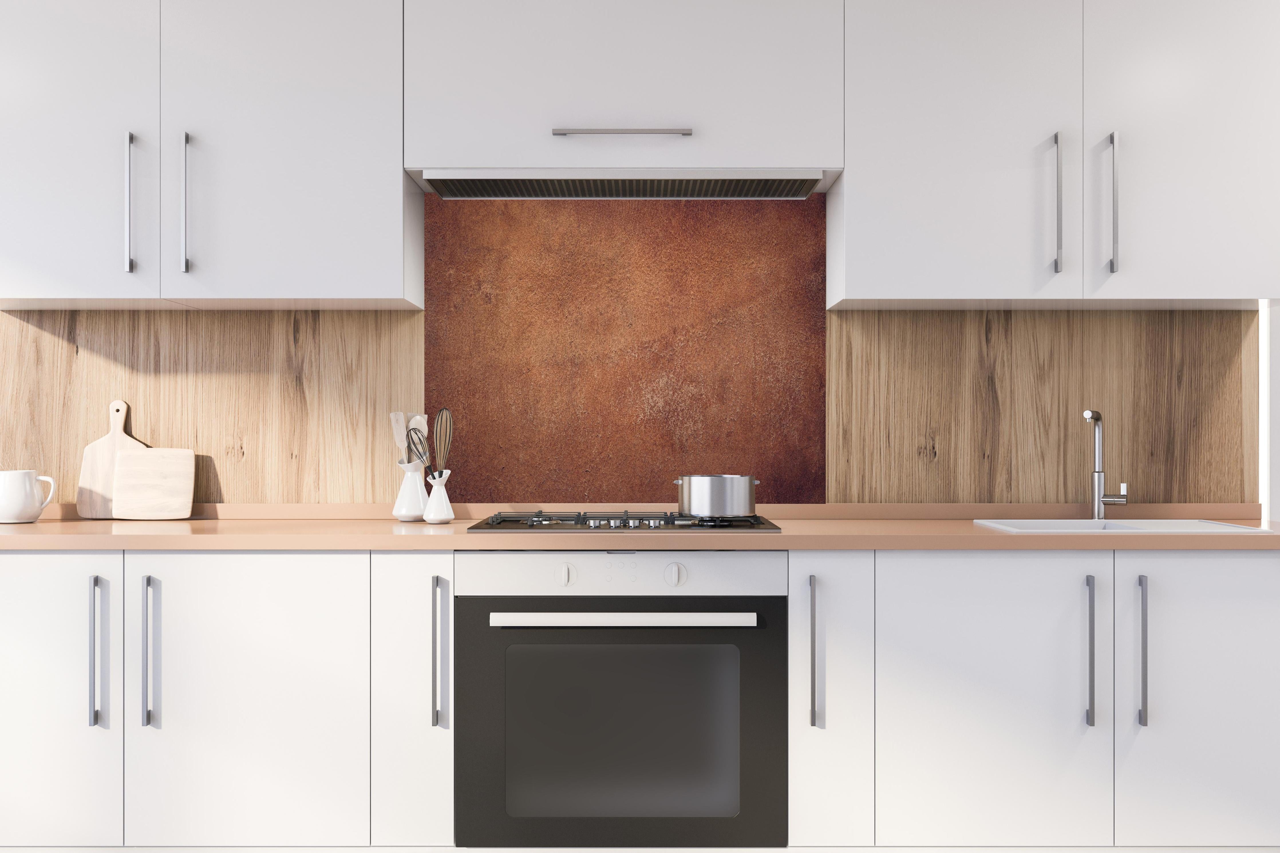 Spritzschutz - Dunkelbraune Ledertextur hinter einem Cerankochfeld zwischen Holz-Kochutensilien
