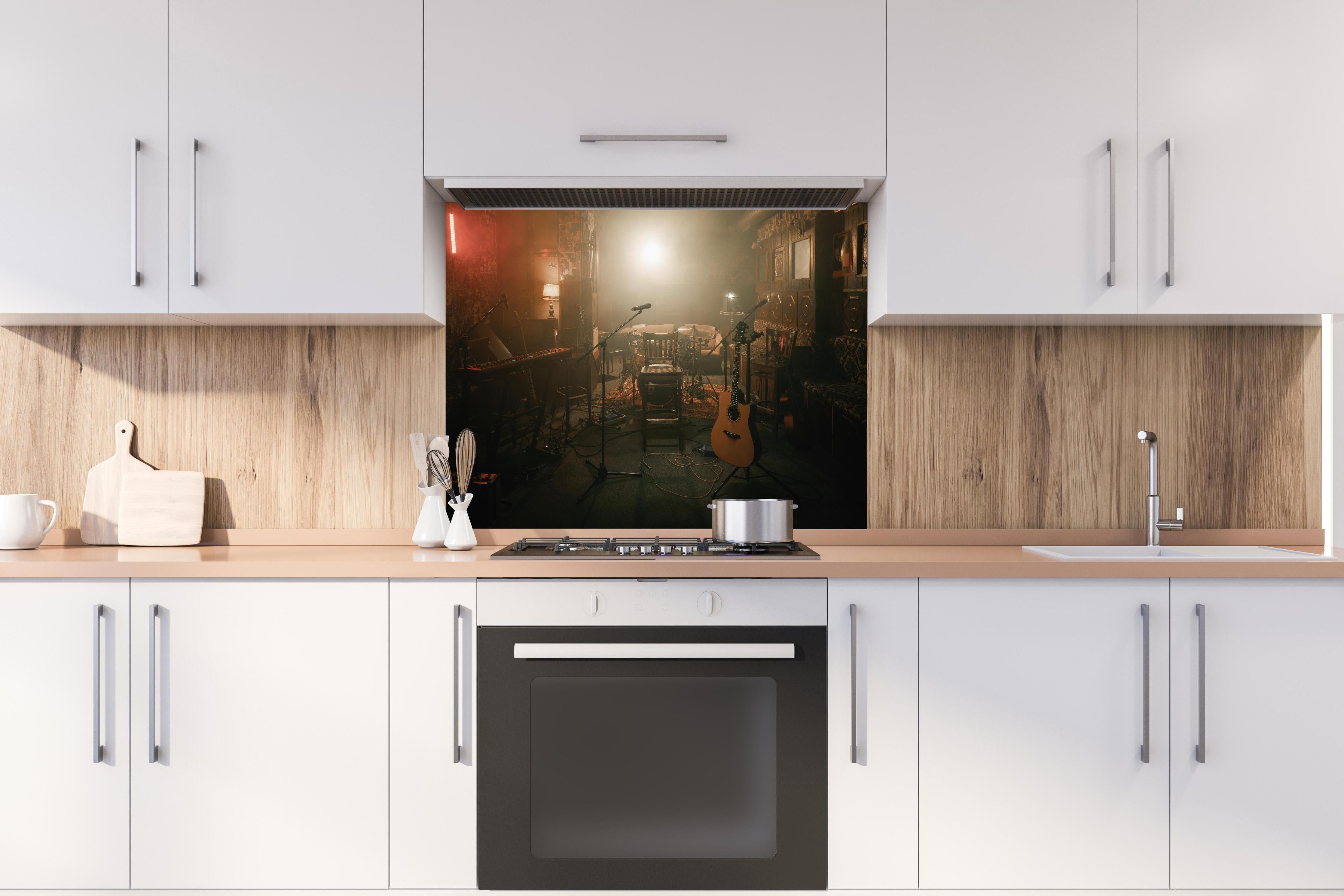 Spritzschutz - Dunkle leere Bühne hinter einem Cerankochfeld zwischen Holz-Kochutensilien
