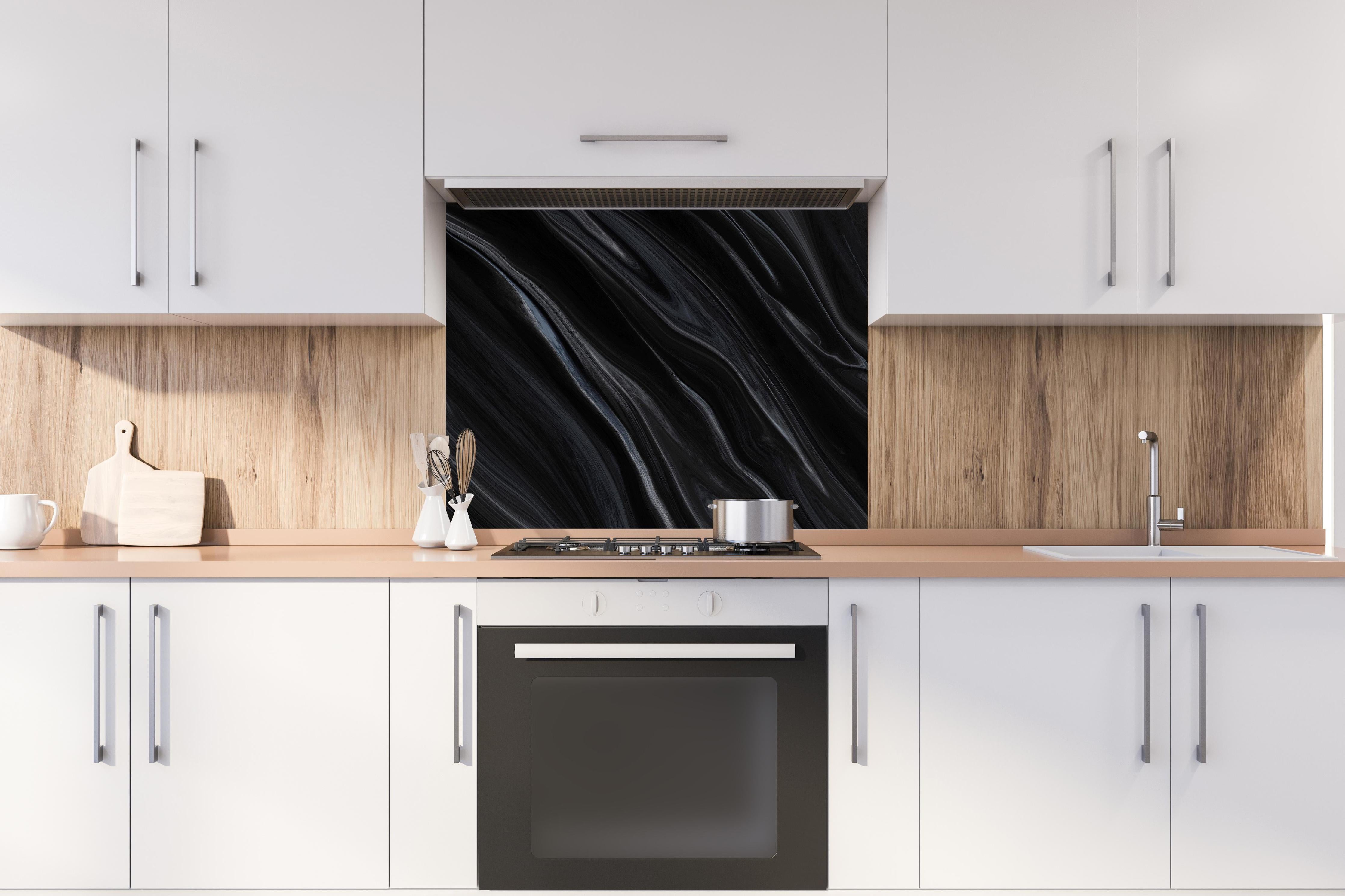 Spritzschutz - Dunkler Seidenhintergrund hinter einem Cerankochfeld zwischen Holz-Kochutensilien
