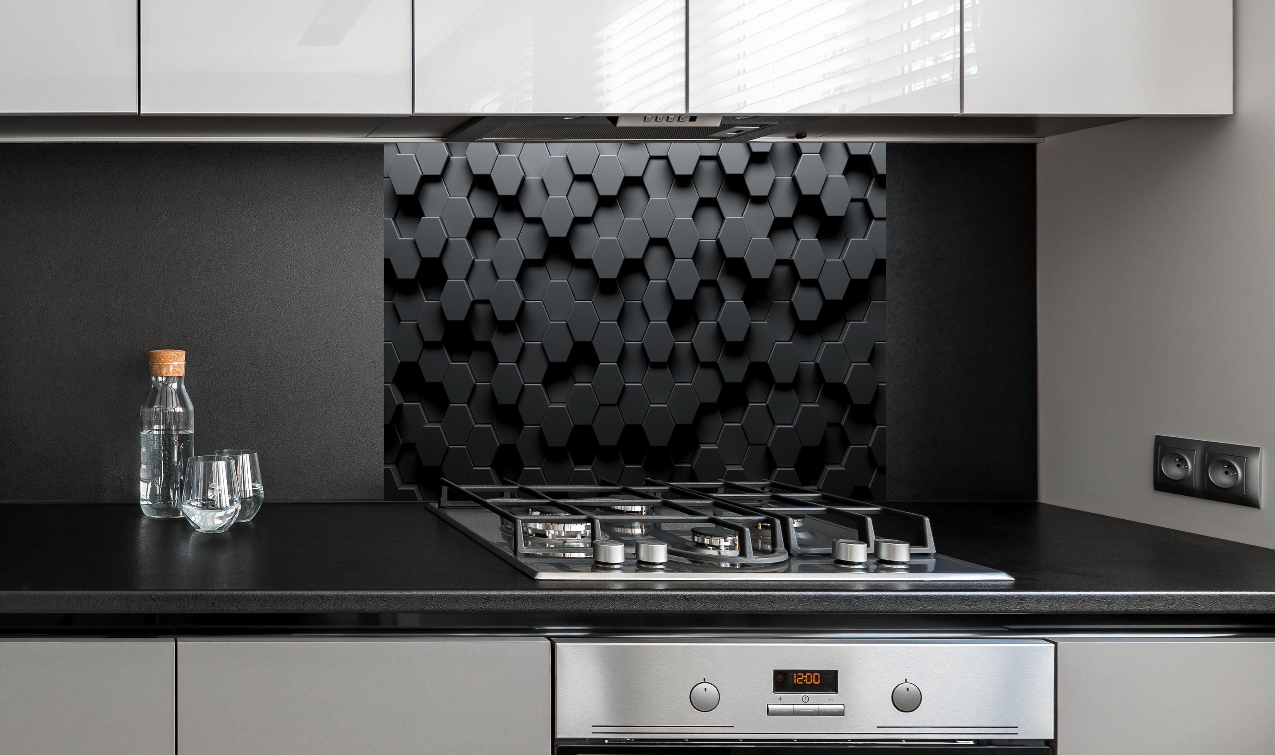 Spritzschutz - Dunkles Sechseck Muster hinter einem Cerankochfeld zwischen Holz-Kochutensilien
