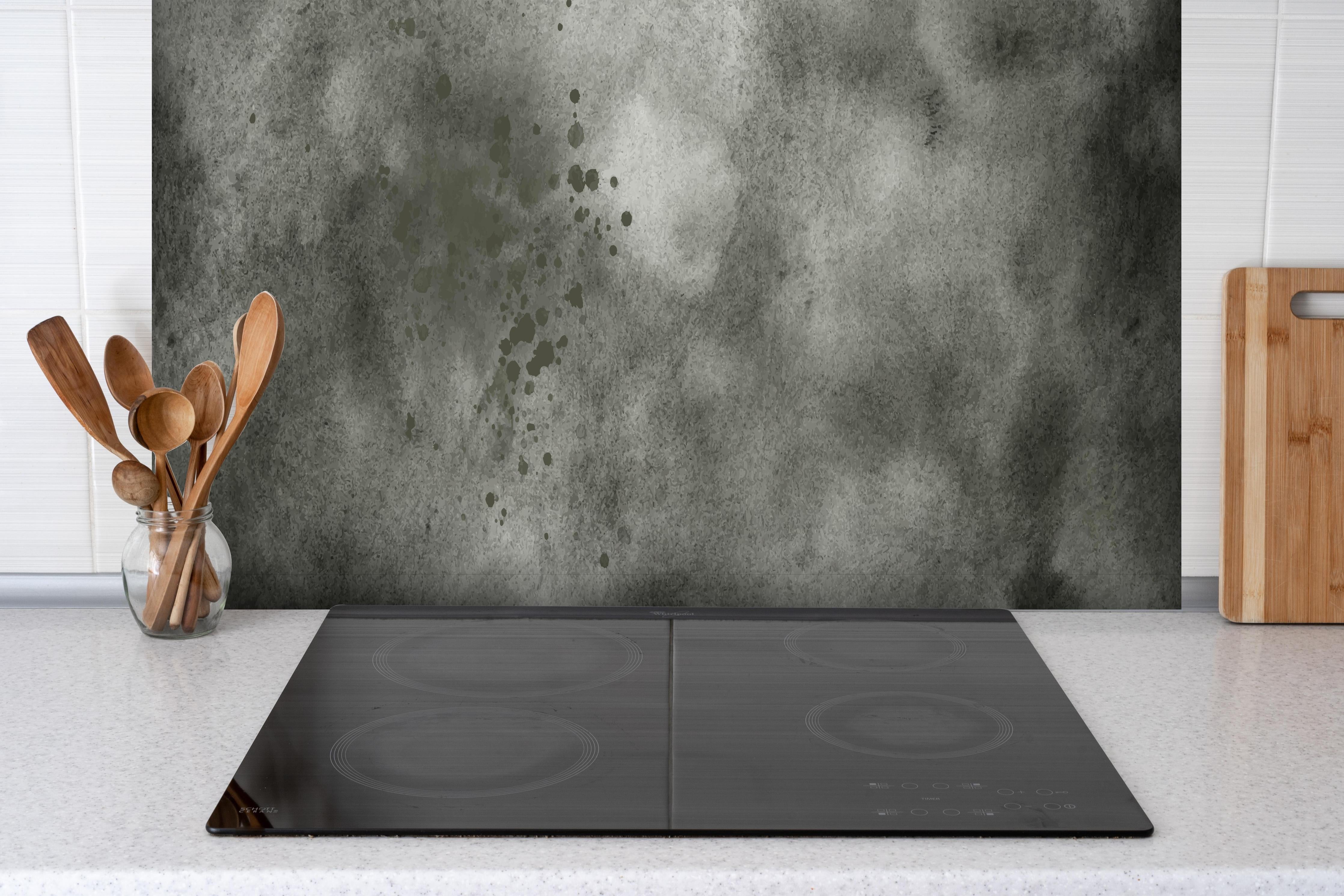 Spritzschutz - Dynamische Aquarelltextur in Grau und Schwarz hinter einem Cerankochfeld zwischen Holz-Kochutensilien
