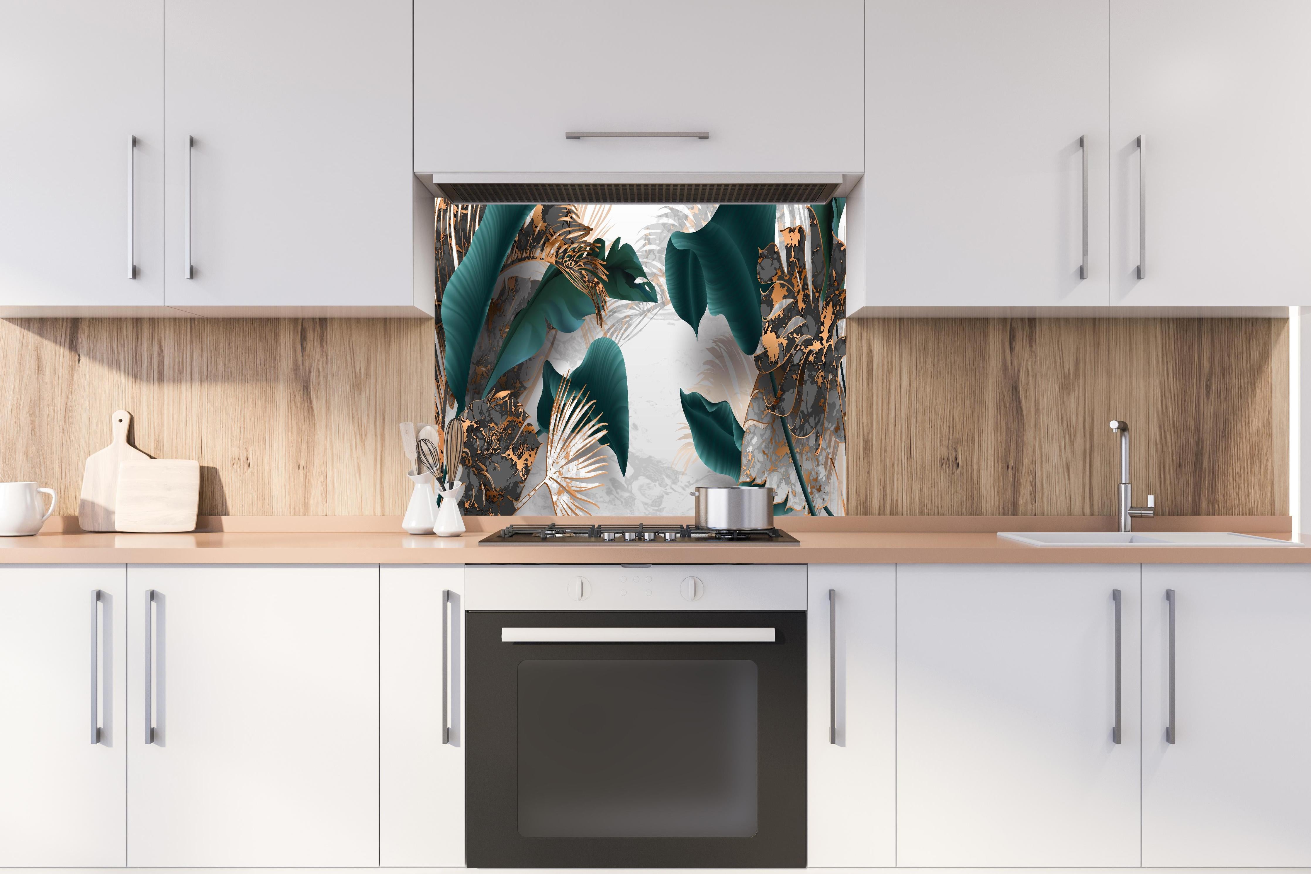 Spritzschutz - Edles Blattwerk in Grün mit Goldakzenten hinter einem Cerankochfeld zwischen Holz-Kochutensilien
