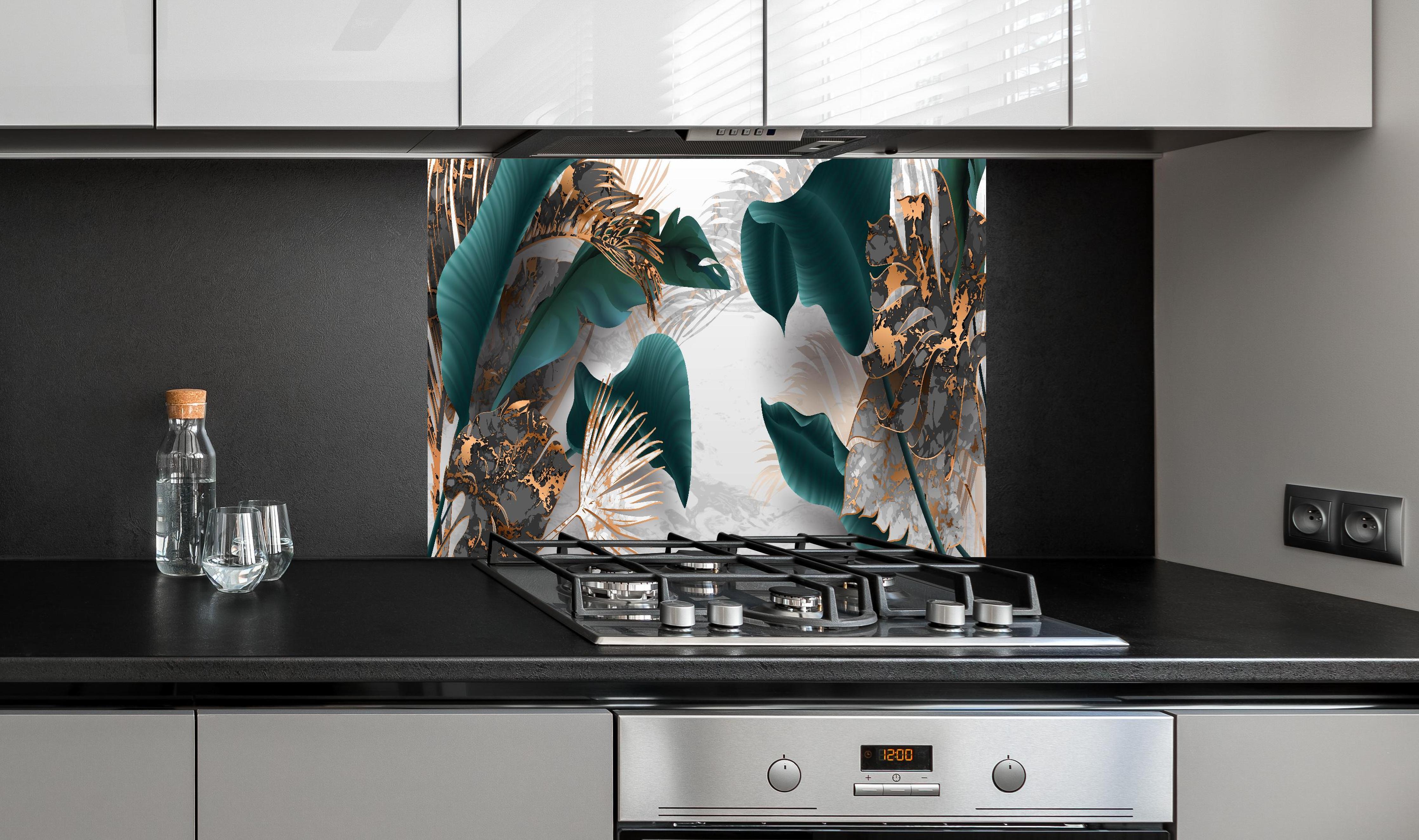 Spritzschutz - Edles Blattwerk in Grün mit Goldakzenten hinter einem Cerankochfeld zwischen Holz-Kochutensilien
