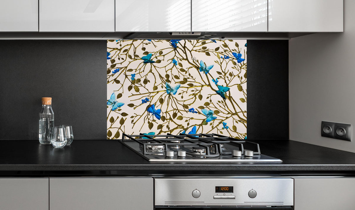 Spritzschutz - Edles Blüten-Design in Blau und Gold hinter einem Cerankochfeld zwischen Holz-Kochutensilien
