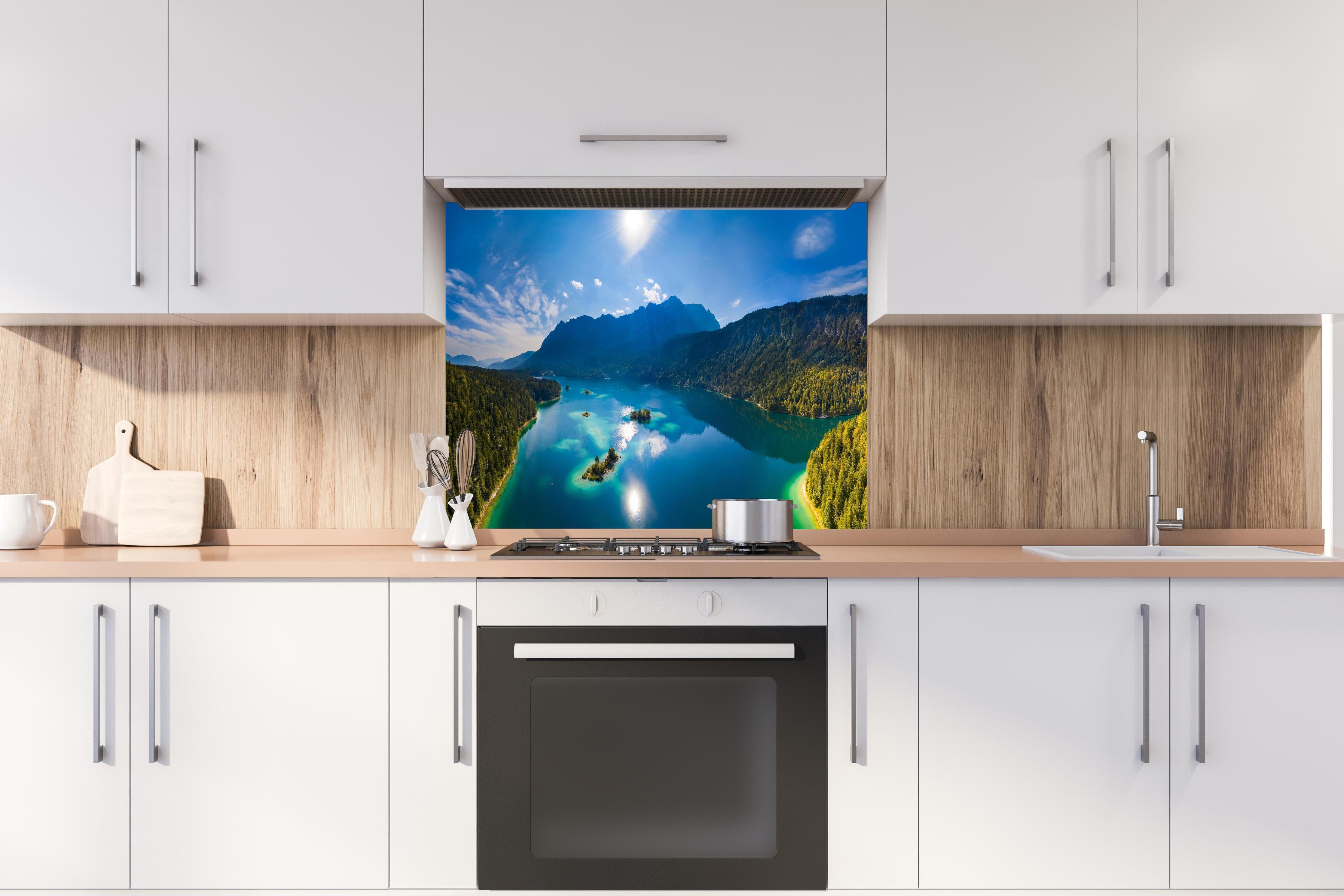 Spritzschutz - Eibsees mit der Zugspitze im Hintergrund hinter einem Cerankochfeld zwischen Holz-Kochutensilien
