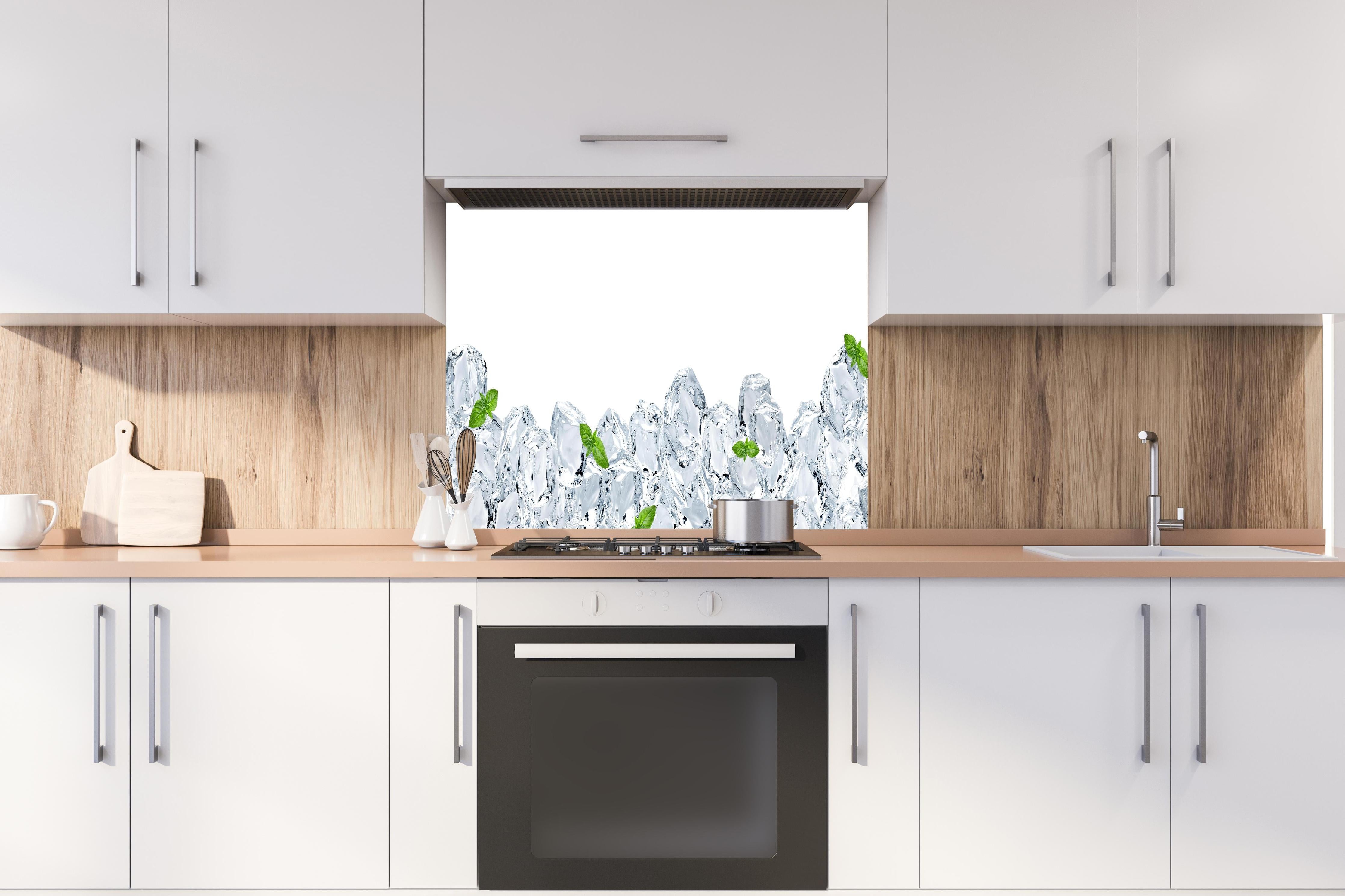 Spritzschutz - Eiswürfel mit einem hauch Minze hinter einem Cerankochfeld zwischen Holz-Kochutensilien
