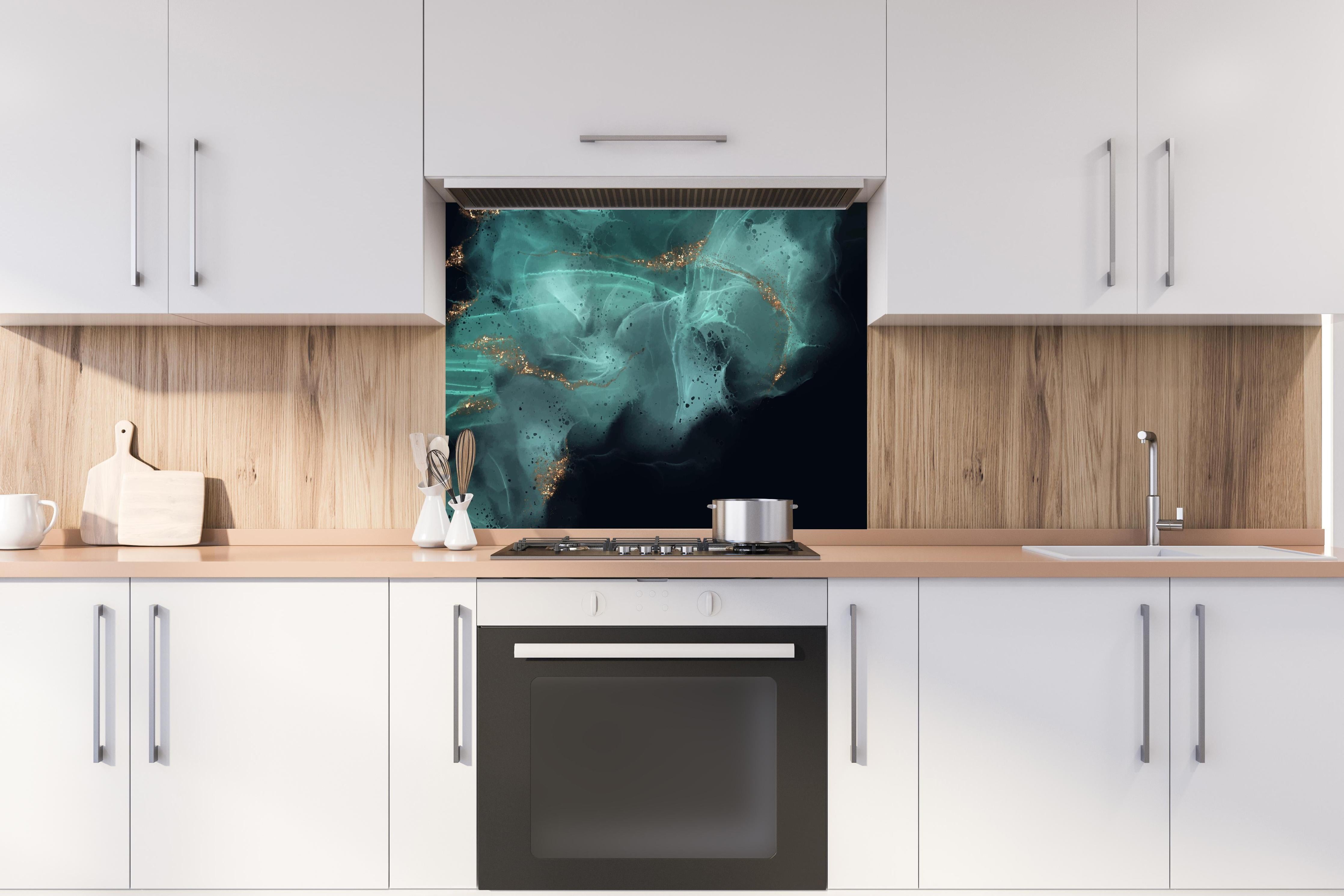 Spritzschutz - Elegante Alkoholtinte in Türkis mit Goldakzent hinter einem Cerankochfeld zwischen Holz-Kochutensilien
