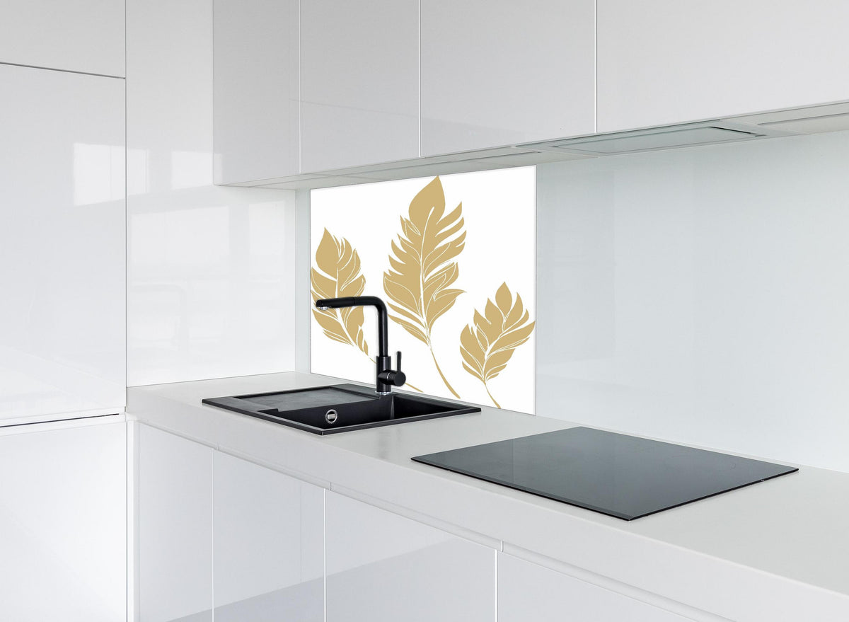 Spritzschutz - Elegante Goldfarbene Feder-Formen Set hinter einem Cerankochfeld zwischen Holz-Kochutensilien
